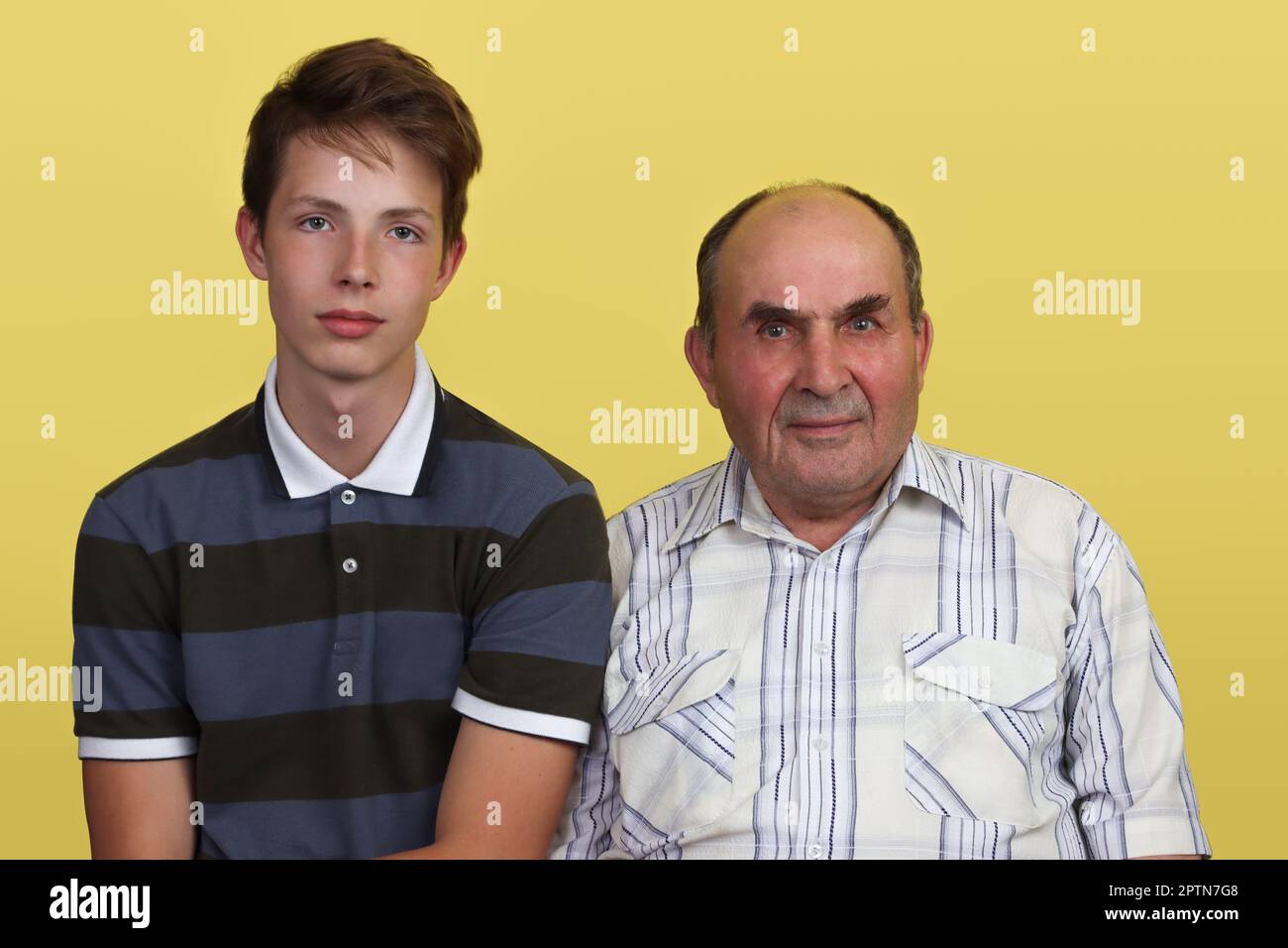 Portrait du grand-père et du petit-fils sur fond jaune. Banque D'Images