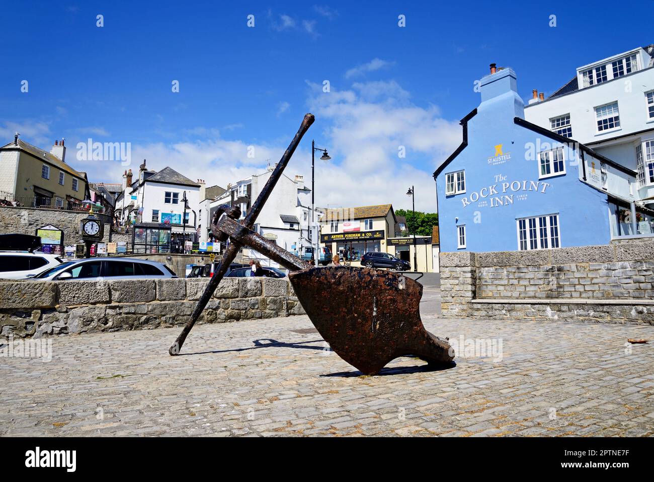 Grande ancre exposée le long du front de mer avec le Rock point Inn et des magasins à l'arrière, Lyme Regis, Dorset, Royaume-Uni, Europe. Banque D'Images