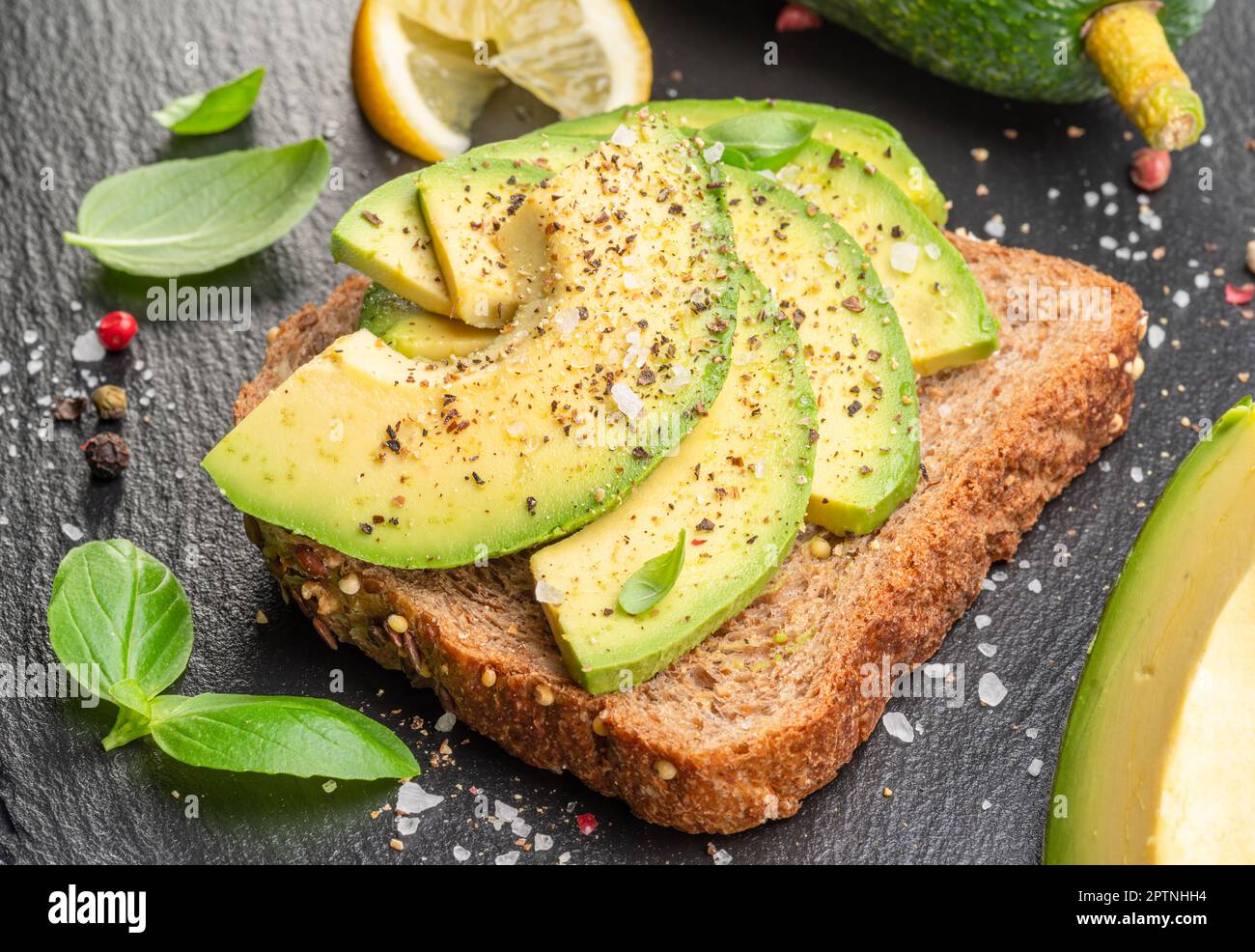 Pain grillé à l'avocat - pain avec tranches d'avocat sur un plateau de service en ardoise naturelle. Vue de dessus. Banque D'Images