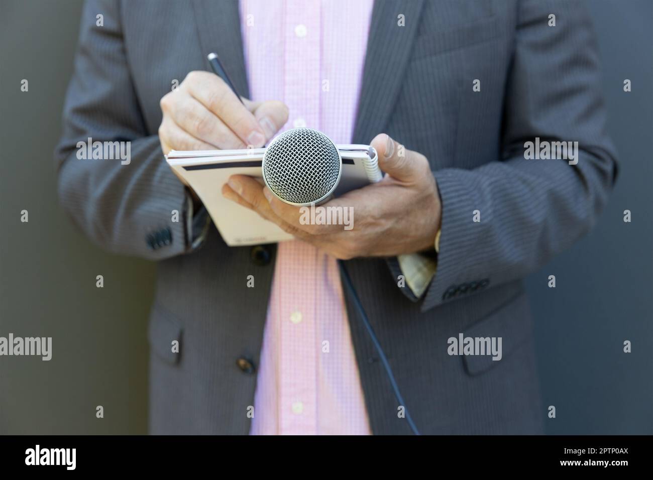 Journaliste lors d'une conférence de presse ou d'un événement médiatique, rédaction de notes, prise d'un micro Banque D'Images