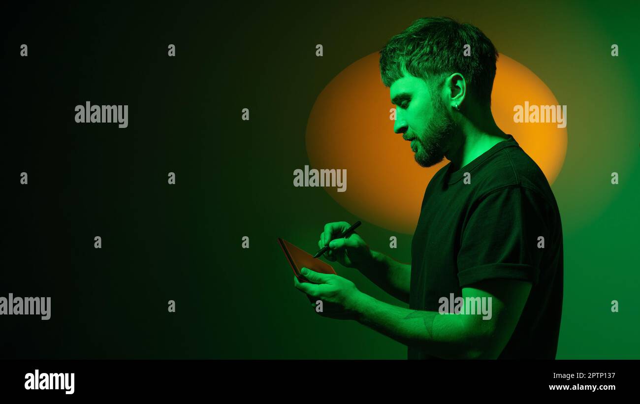 L'artiste CGI dessine à l'aide d'une tablette graphique. Homme de l'industrie du divertissement interactif numérique travaillant avec CGI. L'artiste crée un design de niveau et 3D actifs Banque D'Images