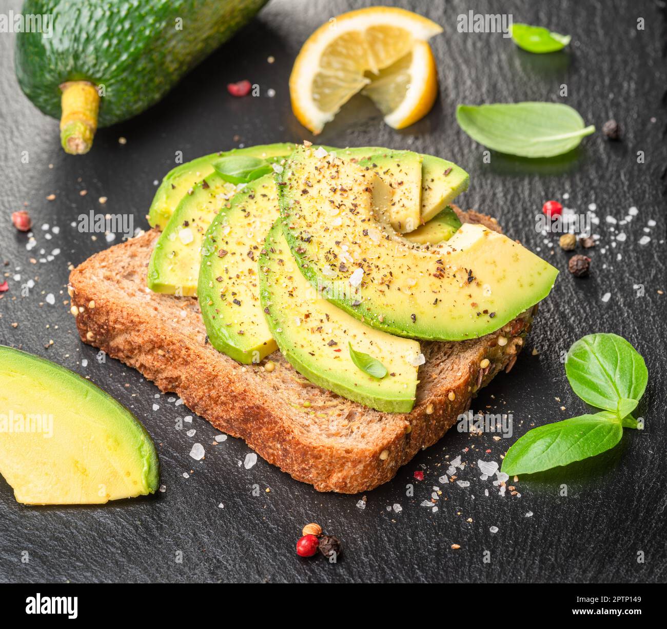 Pain grillé à l'avocat - pain avec tranches d'avocat sur un plateau de service en ardoise naturelle. Vue de dessus. Banque D'Images