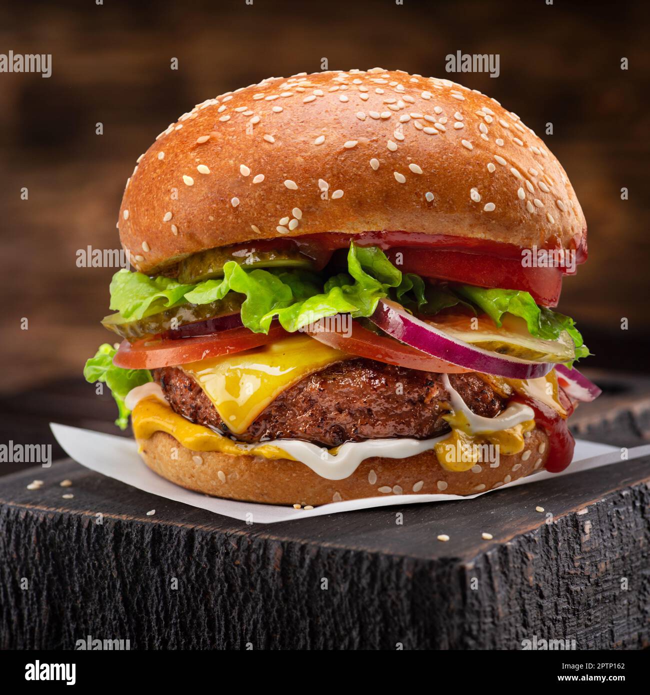 Bon cheeseburger ou hamburger sur plateau en bois gros plan. Banque D'Images