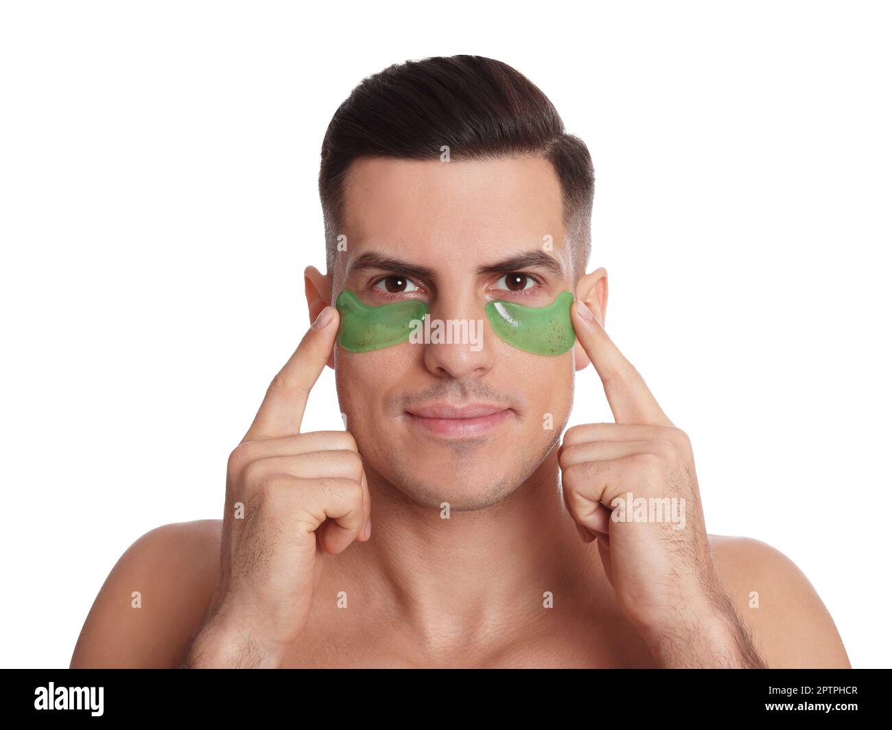 Homme appliquant du vert sous les cellules oculaires sur fond blanc Banque D'Images