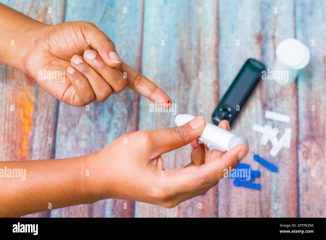 un patient diabétique mesurant le taux de sucre dans le sang à l'aide d'un dispositif. Banque D'Images