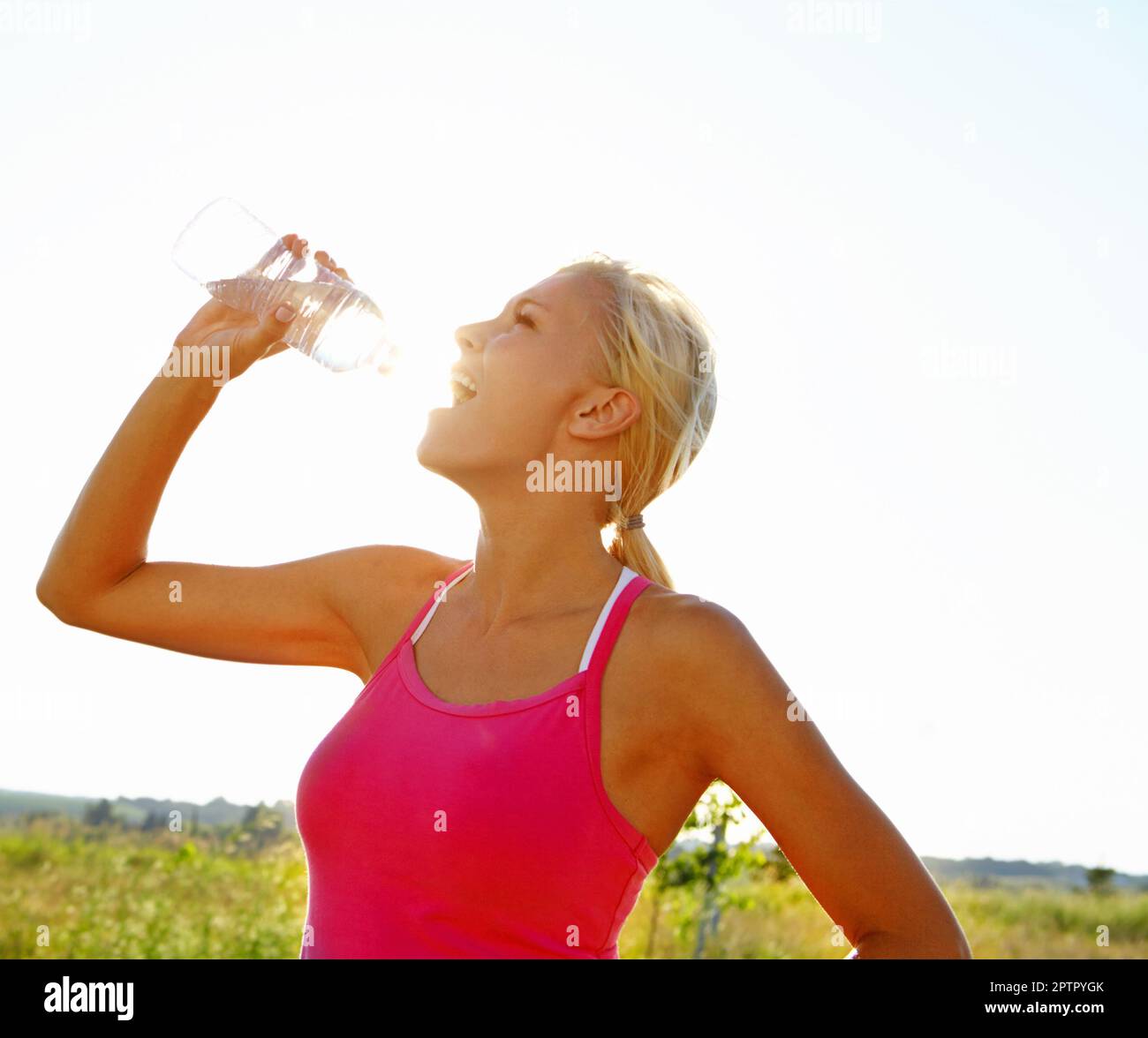 L'hydratation est importante lorsque l'on fait face à un exercice rigoureux. Une belle jeune femme dans l'eau potable de sportswear d'une bouteille Banque D'Images