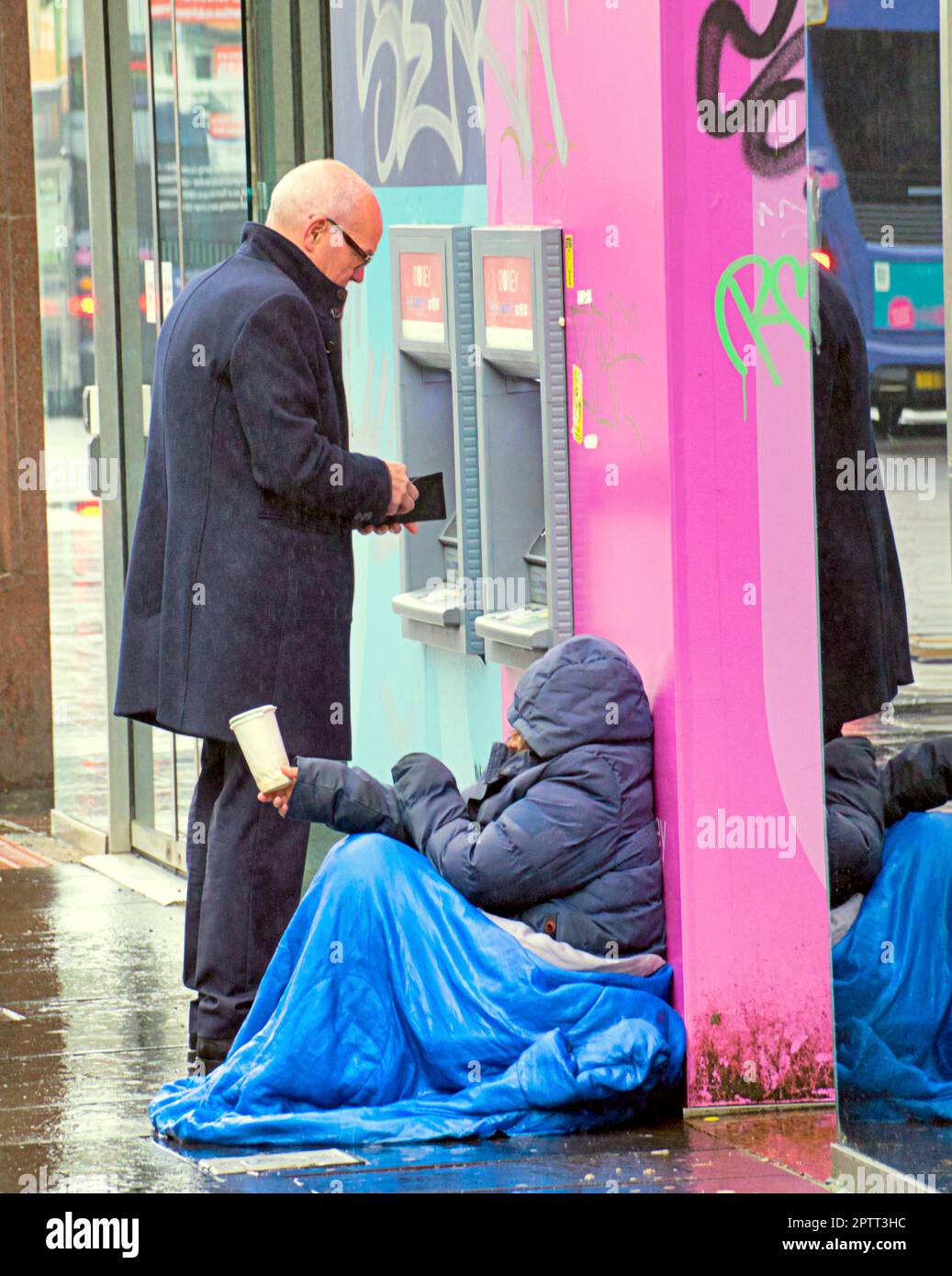 Glasgow, Écosse, Royaume-Uni 28th , avril 2023. Météo au Royaume-Uni : la pluie dans le style de la ville Mile la capitale commerçante de la rue scotland Buchanan en tant que mendiant tente sa chance à côté d'une machine à billets. Crédit Gerard Ferry/Alay Live News Banque D'Images