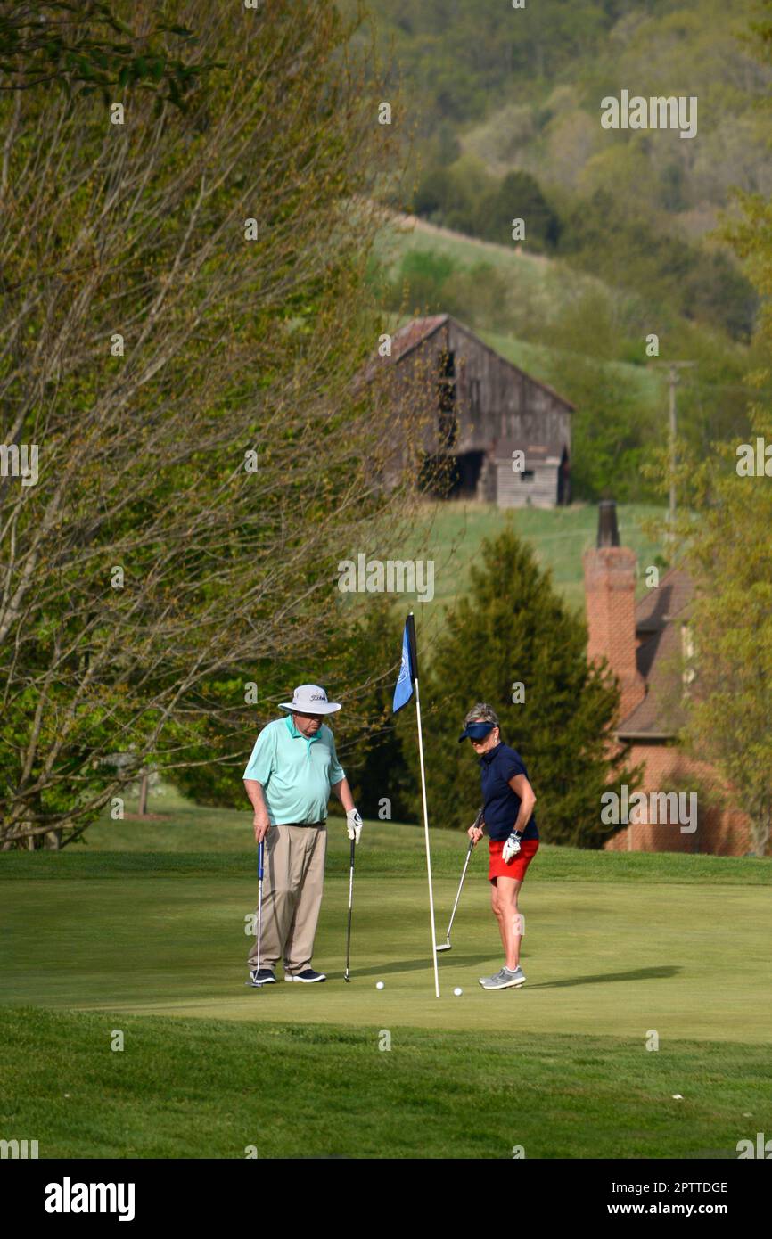 Un couple joue au golf sur un terrain de golf du country club gof à Abingdon, en Virginie. Banque D'Images