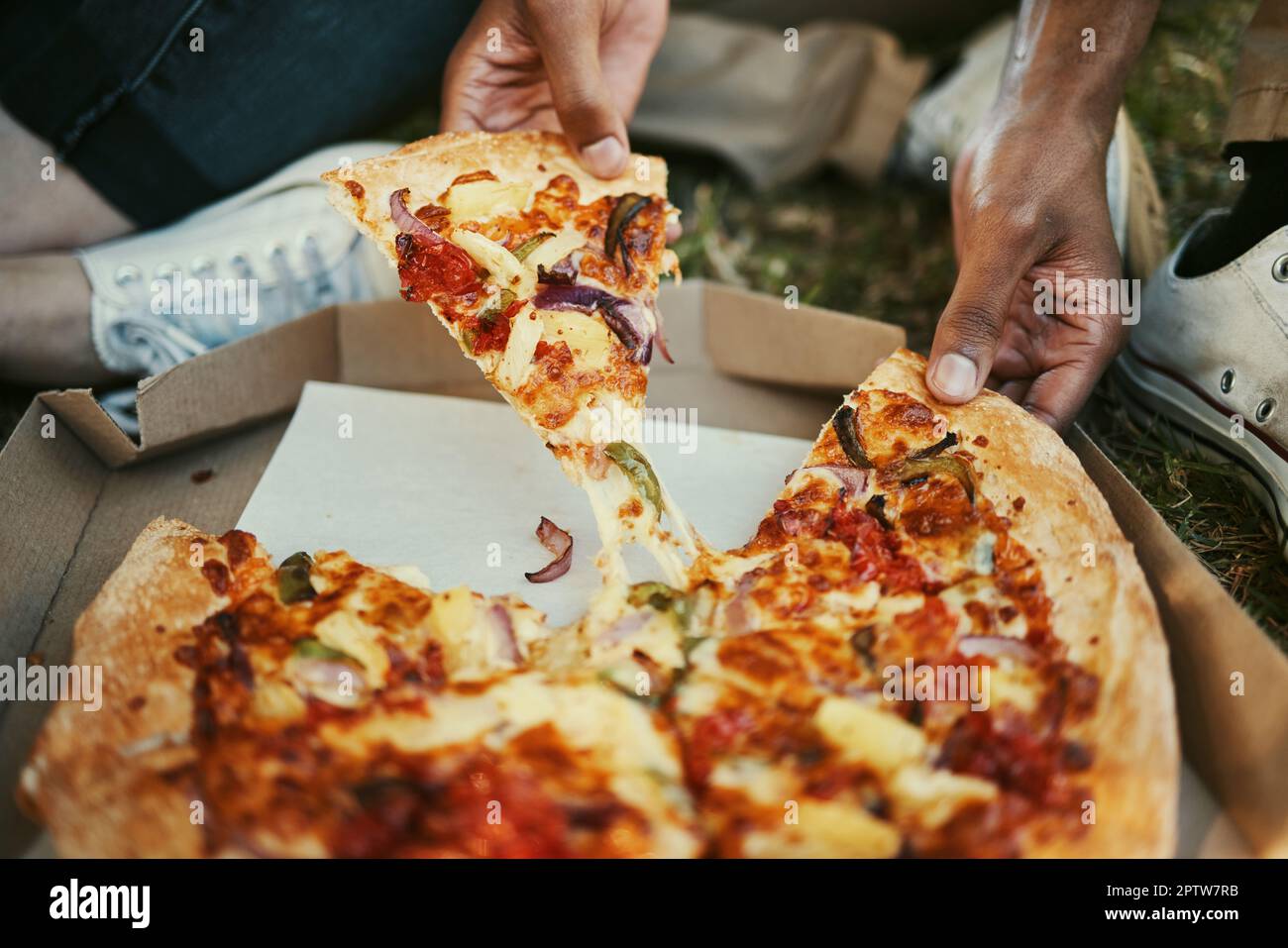 Pizza, nourriture et mains d'un couple manger dans un parc, pique-nique et  se détendre sur une date extérieure ensemble. Faim, restauration rapide et  zoom de l'homme et de la femme avec lun