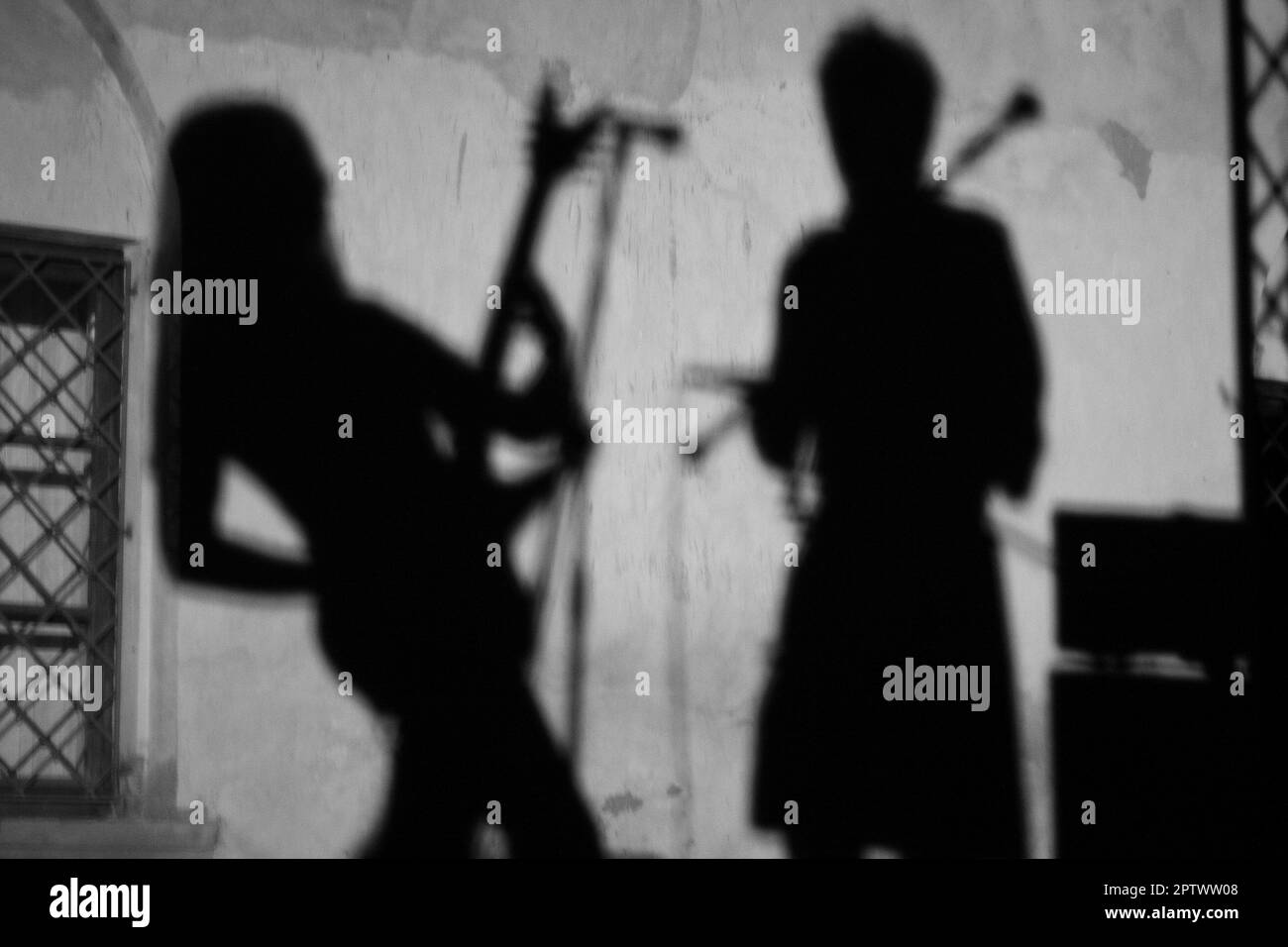 sur le mur l'ombre d'un musicien guitariste lors d'un concert Banque D'Images