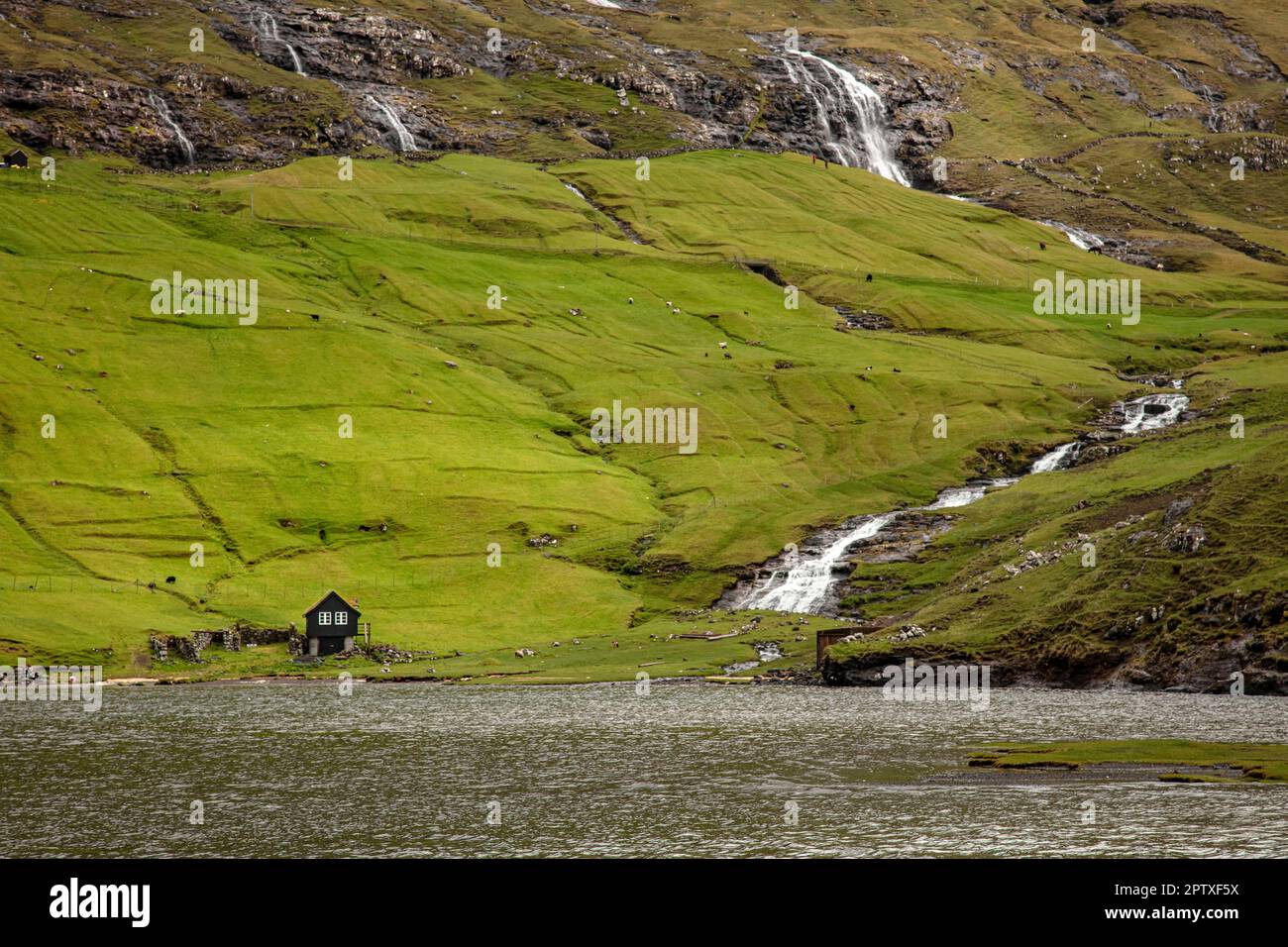 maison isolée et cascades dans la région de saksun sur les îles féroé Banque D'Images