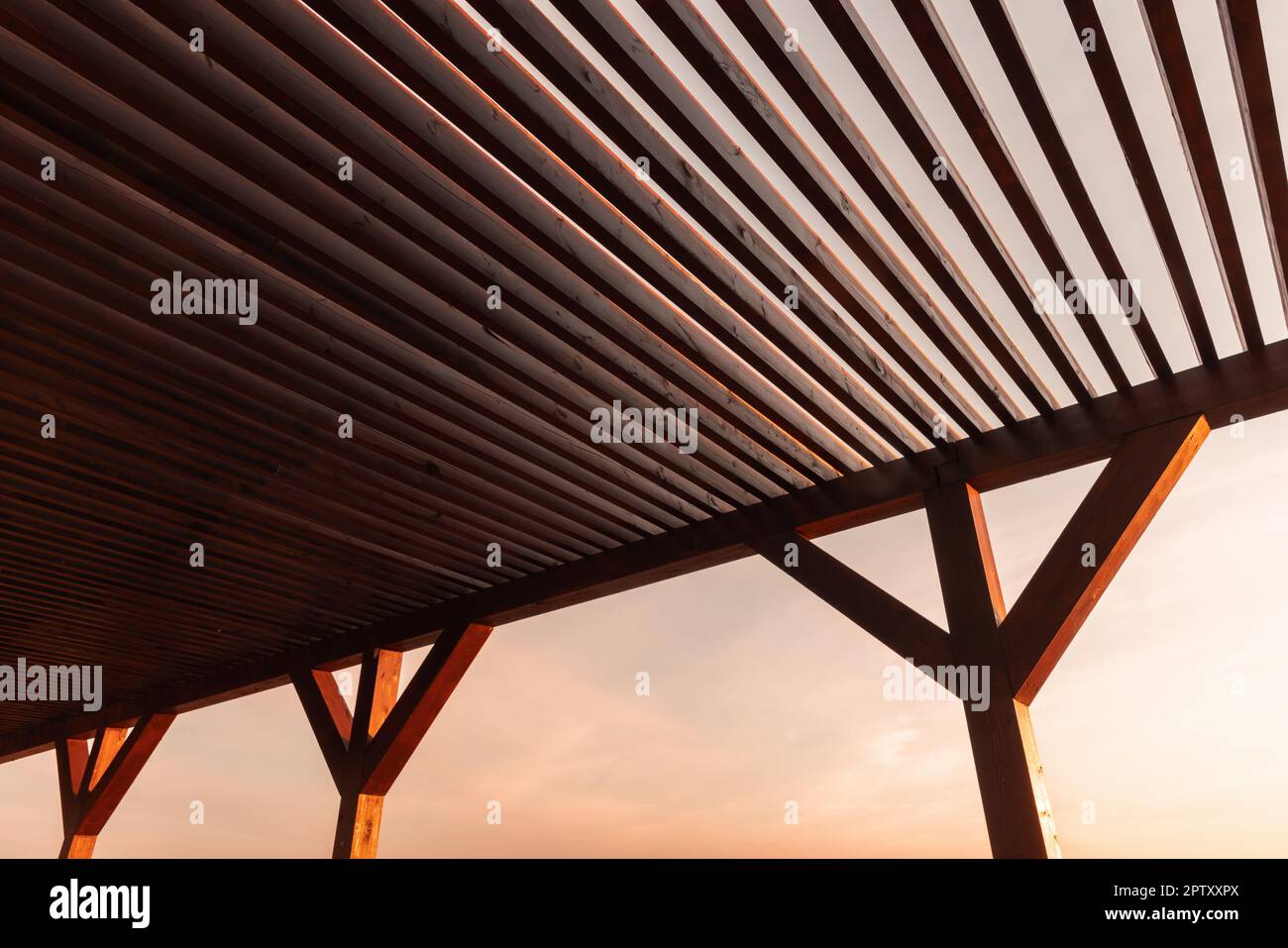Le toit en bois pare-soleil est sous le ciel du soir, un arrière-plan abstrait de la photo d'architecture Banque D'Images