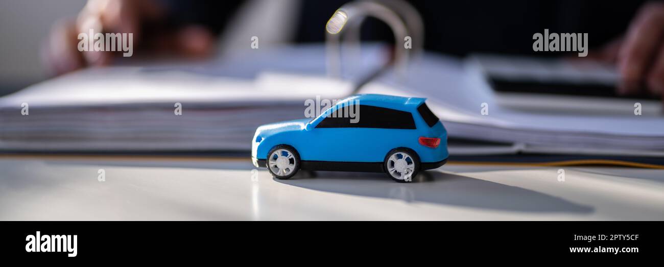 Blue Toy Car Devant Un Homme D'Affaires Calculant Le Prêt Banque D'Images