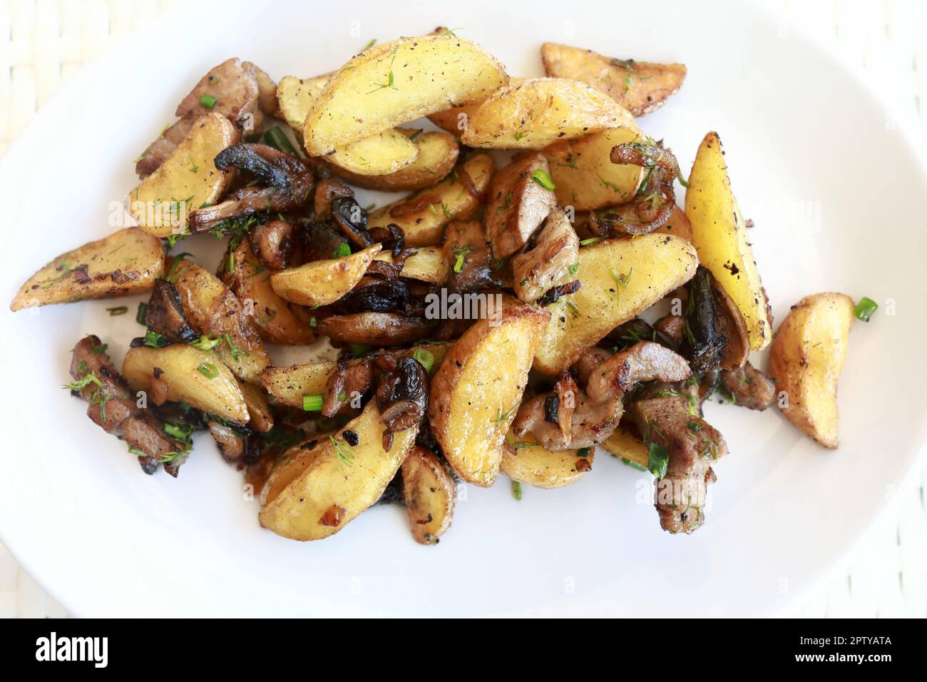 Pommes de terre frites aux champignons sur l'assiette du restaurant Banque D'Images