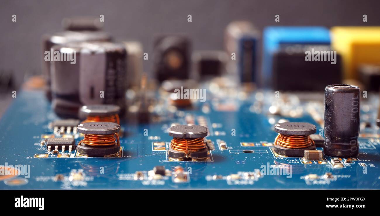 Arrière-plan des composants électroniques. Gros plan des bobines sur la carte de circuit imprimé industrielle. Banque D'Images