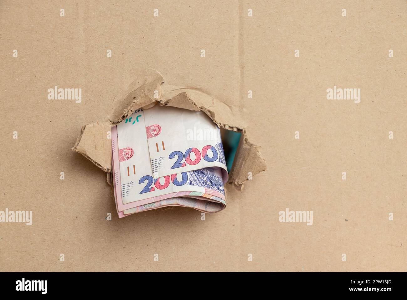 200 hryvnias sortir d'un trou dans le carton, affaires Banque D'Images