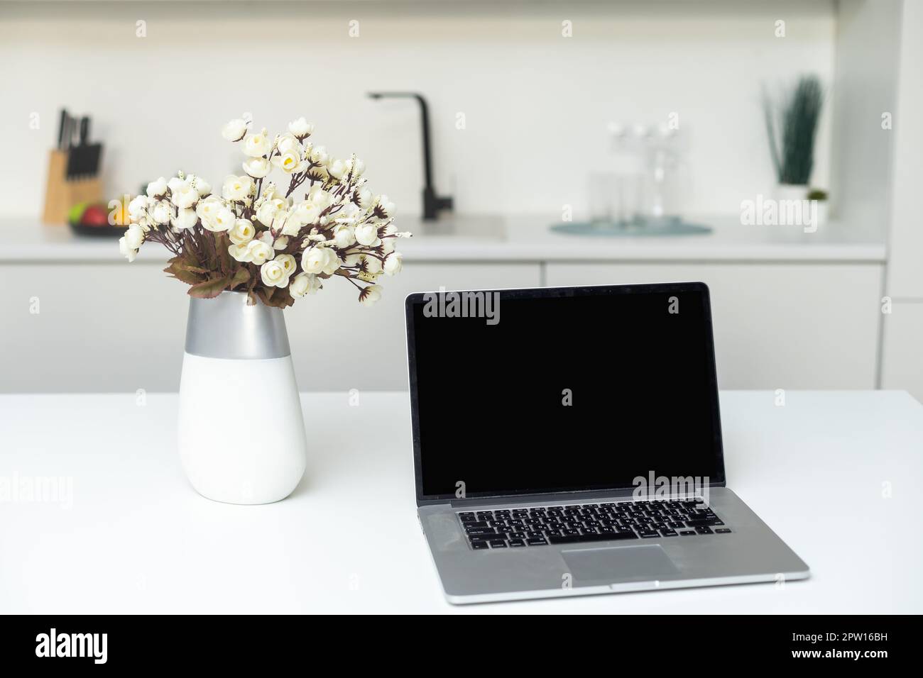 Concept culinaire des médias sociaux, vue de face d'un ordinateur portable et d'ustensiles sur le comptoir de cuisine moderne Banque D'Images
