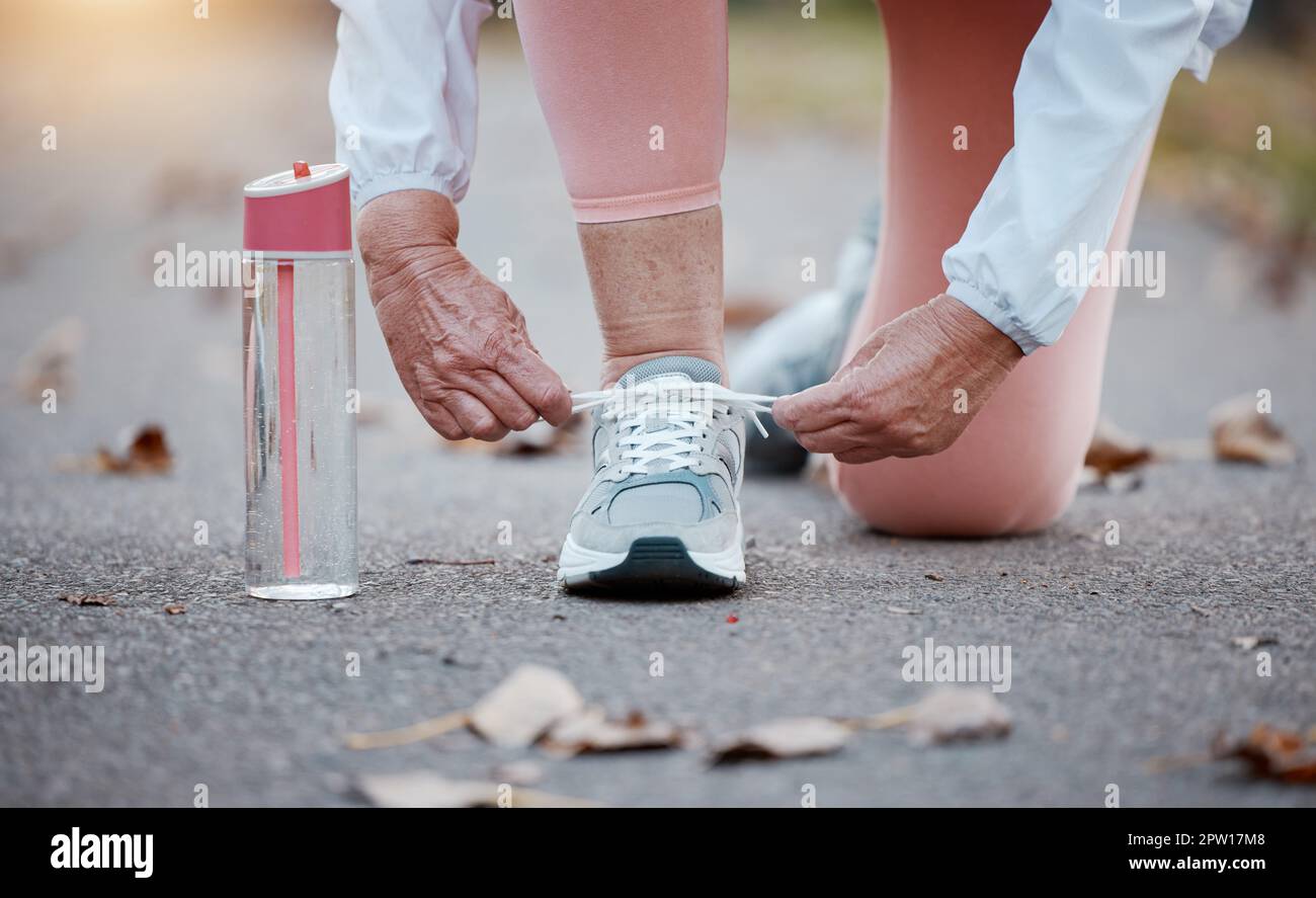 Femme senior, main et préparer des chaussures pour la course ou le fitness  personne dans la rue cravate dentelle pour la course, cardio ou de la  marche. Exercice, entraînement ou entraînement de
