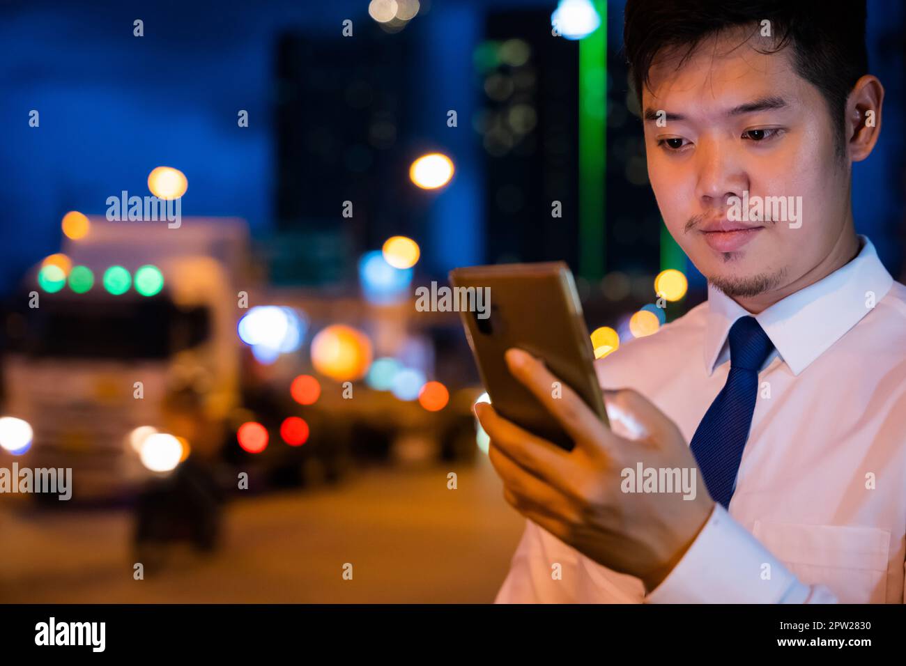 Jeune homme marchant et bavardant sur un téléphone mobile avec des amis sur les réseaux sociaux en plein air, homme d'affaires de Portrait Asian tapant un sms via smartphon Banque D'Images