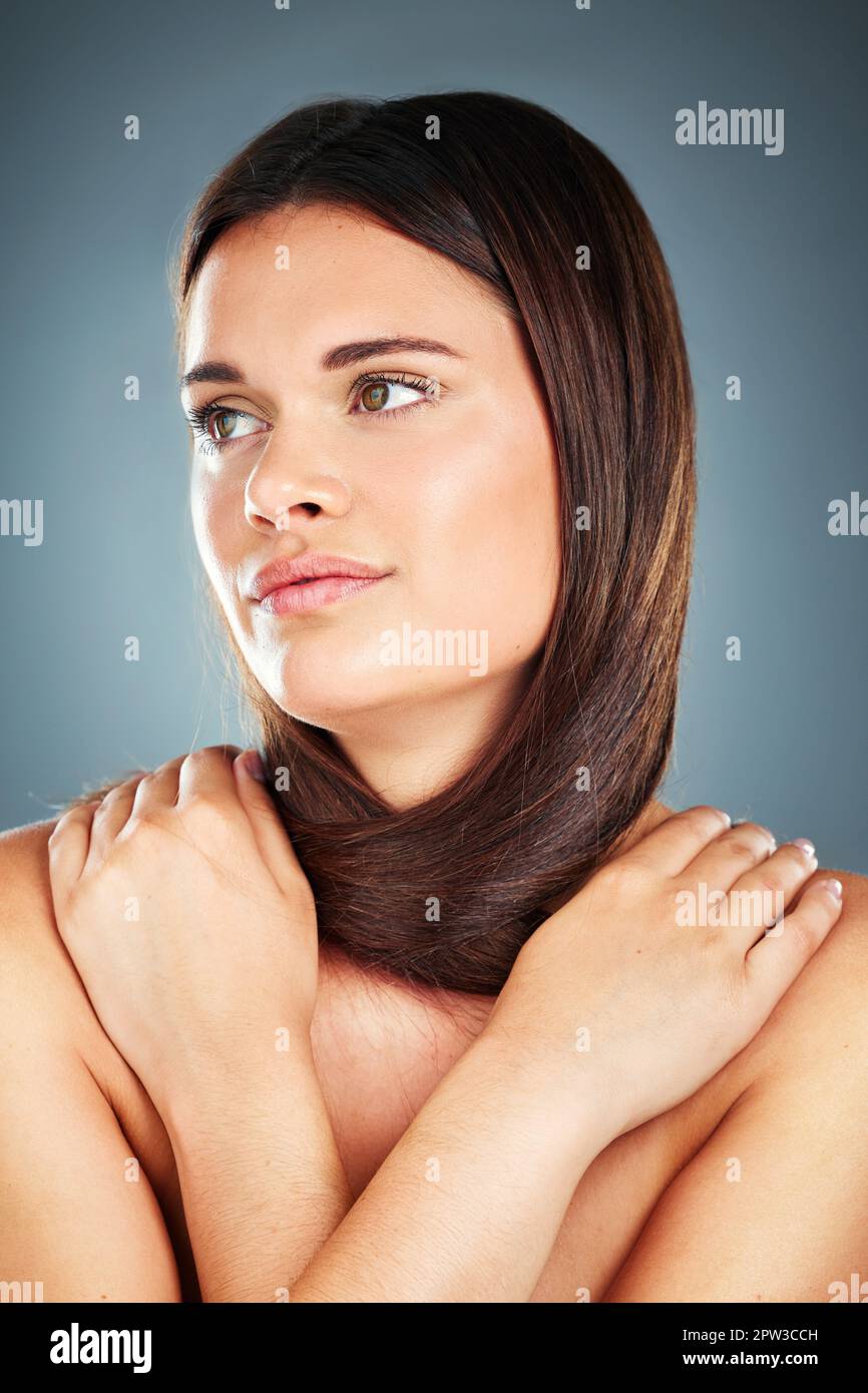 Soins capillaires, beauté et visage de la femme en studio sur fond gris pose pour la publicité de salon de coiffure. Cosmétiques, mode et fille avec les cheveux autour du cou FO Banque D'Images