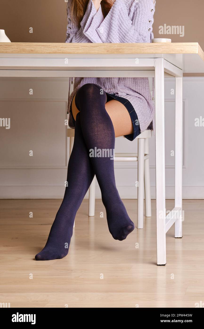 Jambes de femmes en chaussettes chaudes au-dessus du genou sous la table  Photo Stock - Alamy