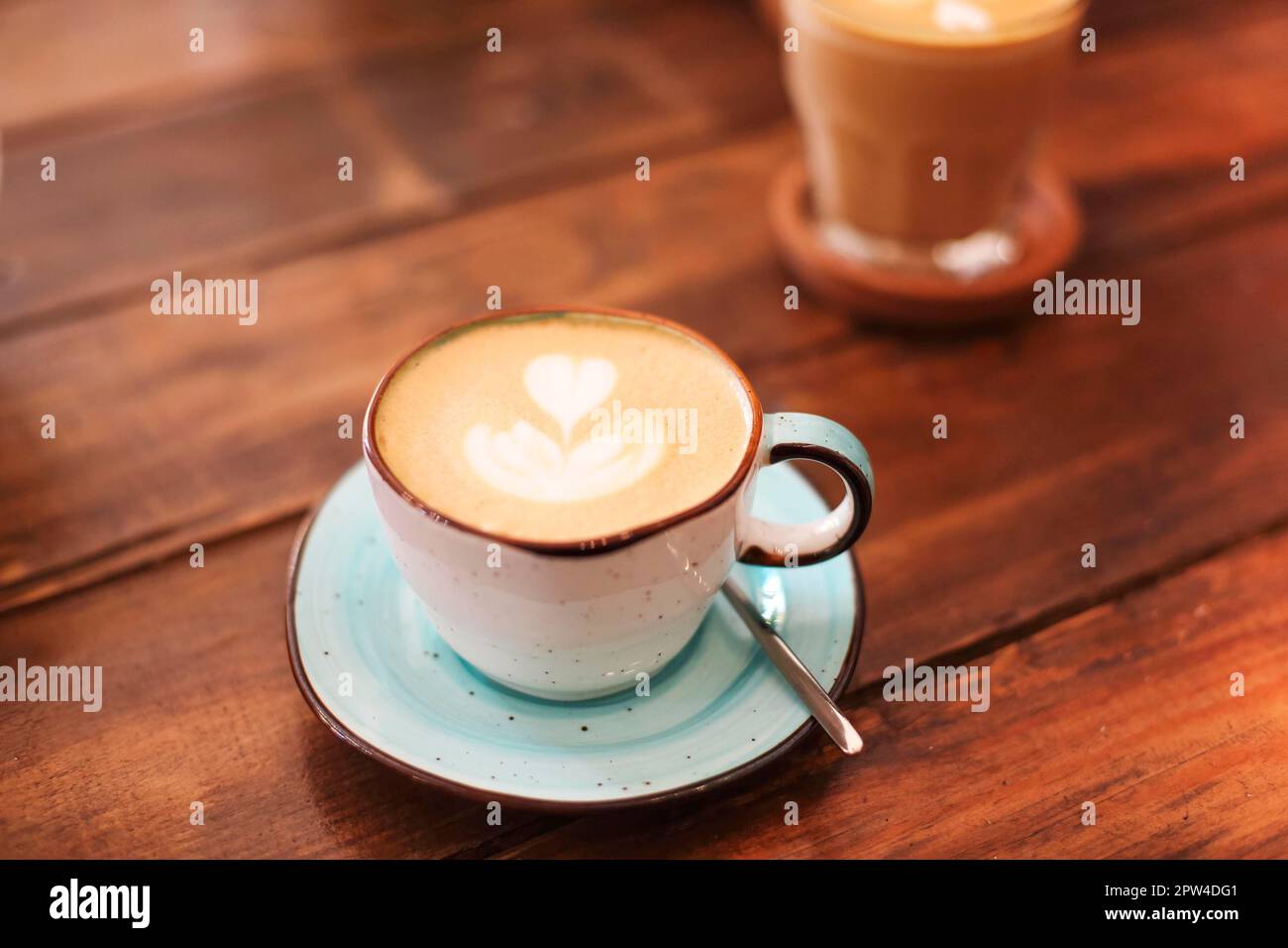 Du dessus des tasses en céramique sur les soucoupes fraîchement brassées latte avec les cœurs sur la mousse Banque D'Images