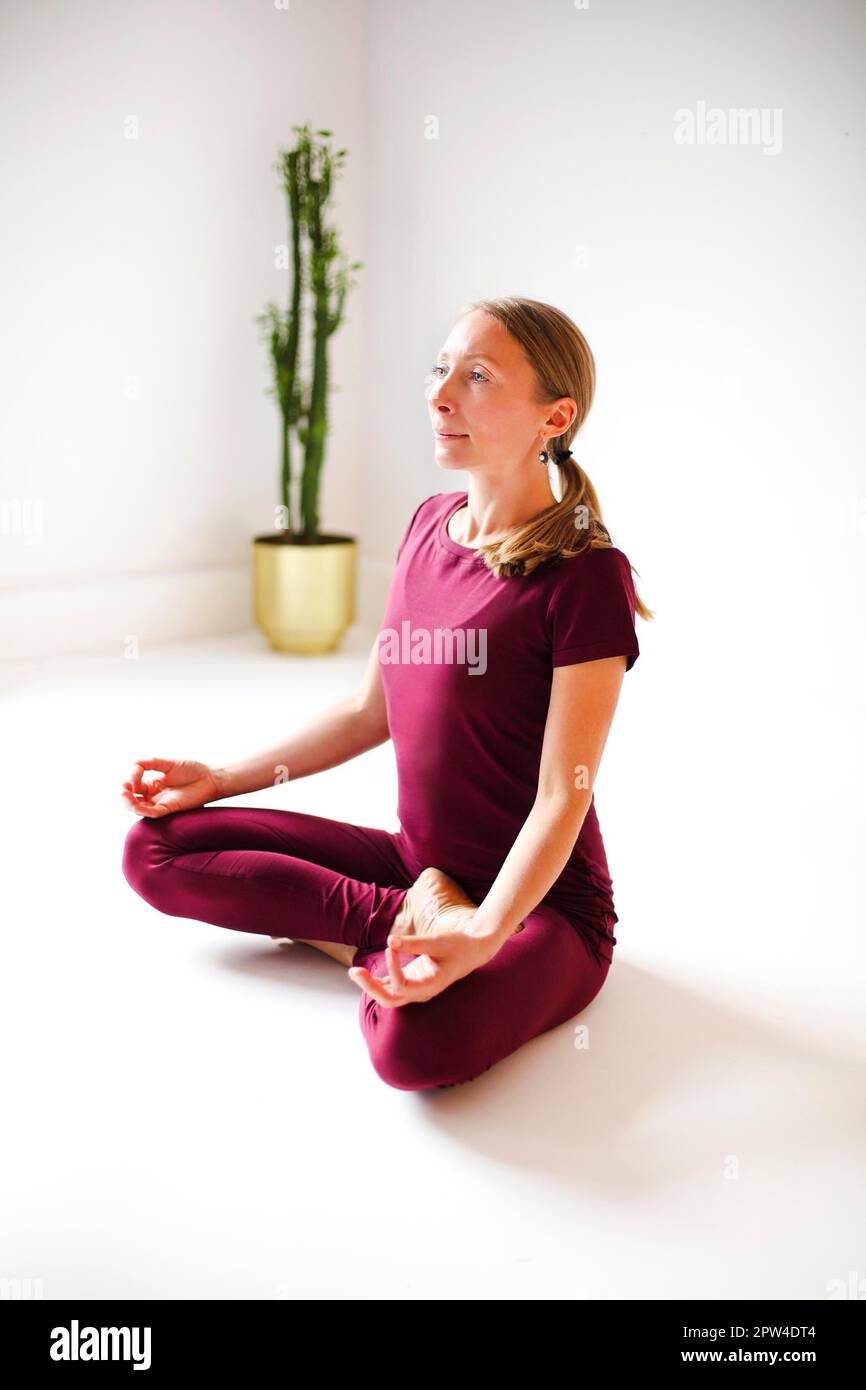 Calme femme dans les vêtements de sport pratiquant le yoga dans la posture de Firefly tout en équilibrant et en regardant loin Banque D'Images