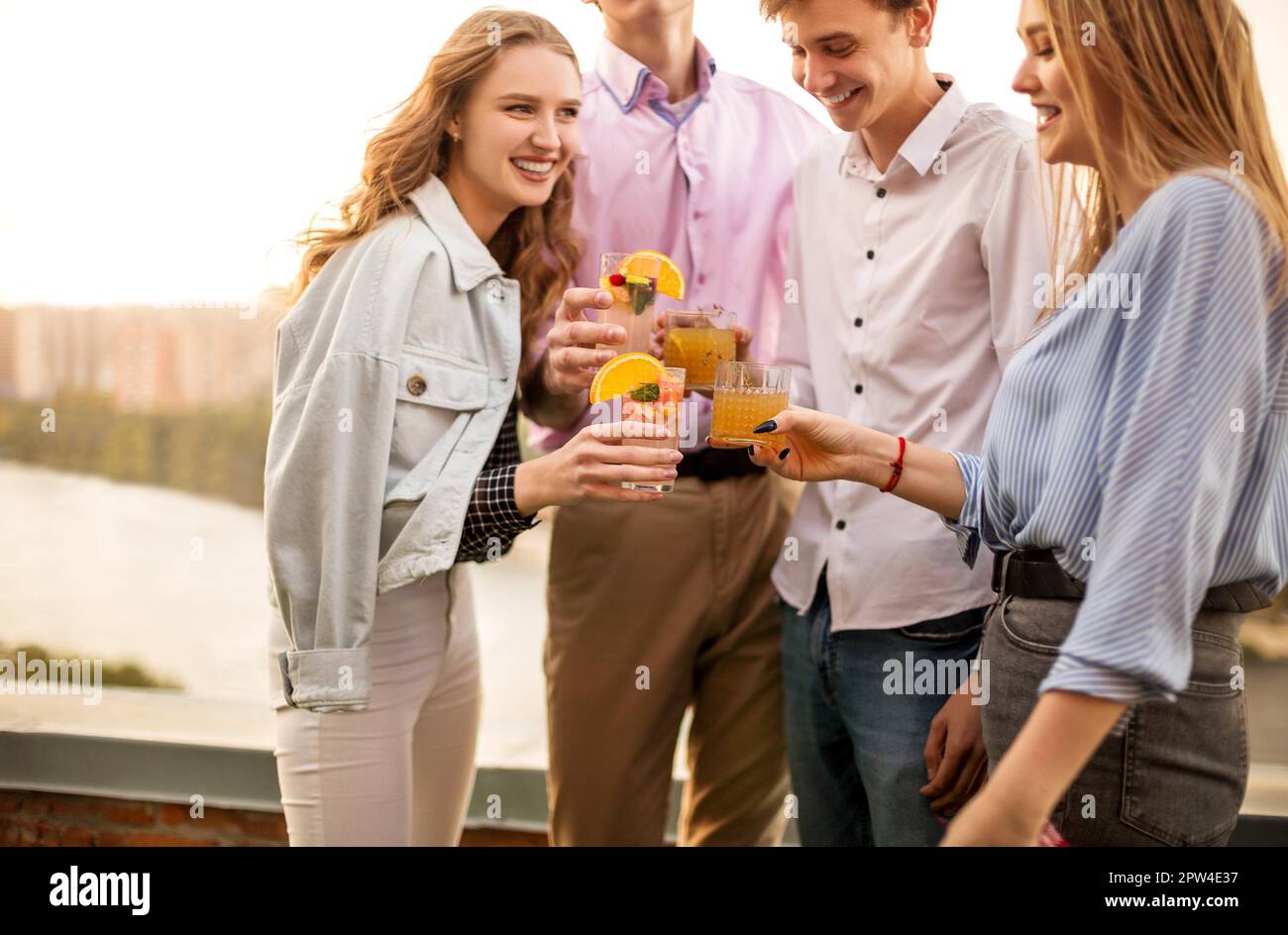 Des hommes et des femmes heureux se sont contentés de prendre des verres de cocktails de fruits et de proposer des toasts pendant la fête Banque D'Images