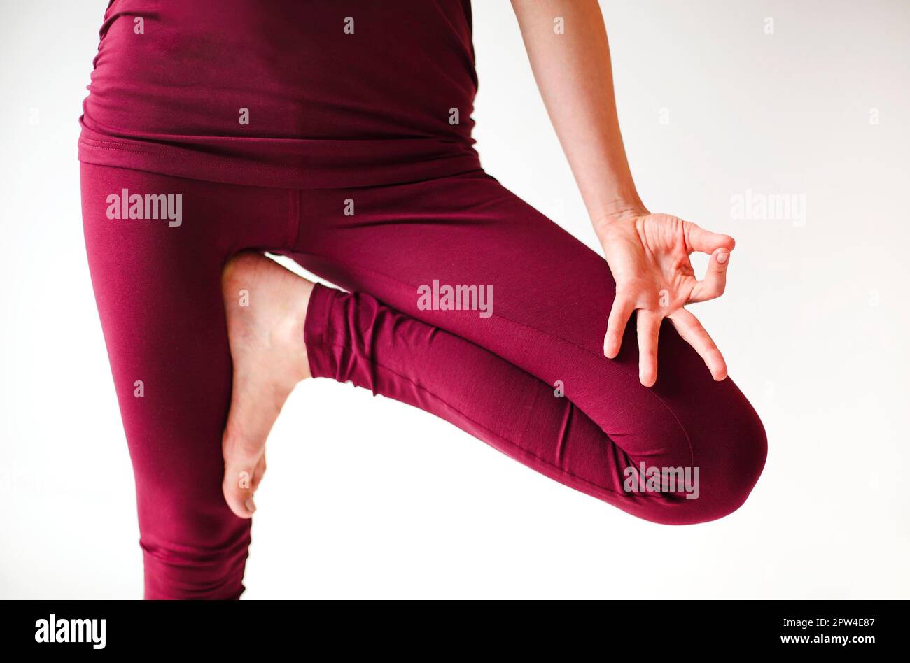 Femme méconnue dans les vêtements de sport assis avec les jambes croisées et les mains mudra sur le tapis et faisant du yoga tout en pratiquant la pleine conscience Banque D'Images