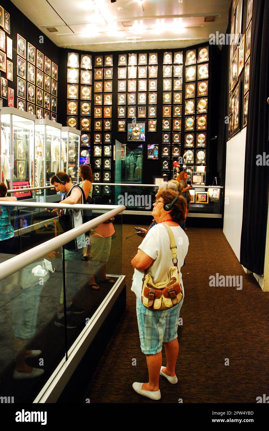 Une femme adulte admire les records d'or d'Elvis Presley ornant les murs de la salle des trophées, à Graceland, à Memphis, Tennessee Banque D'Images