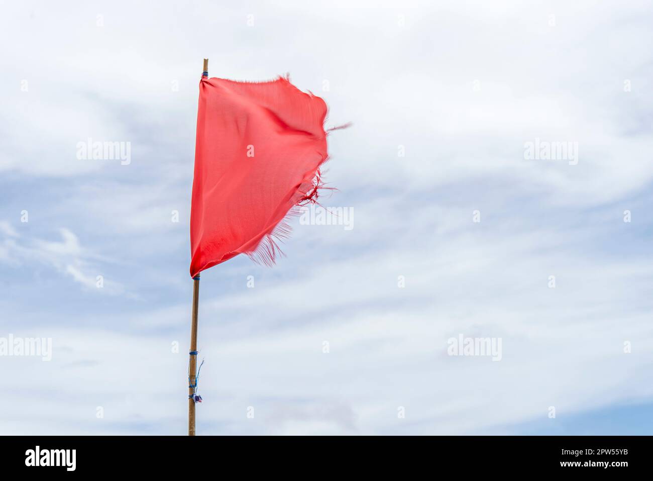 Drapeau rouge drapeaux d'avertissement vent bleu ciel Banque D'Images