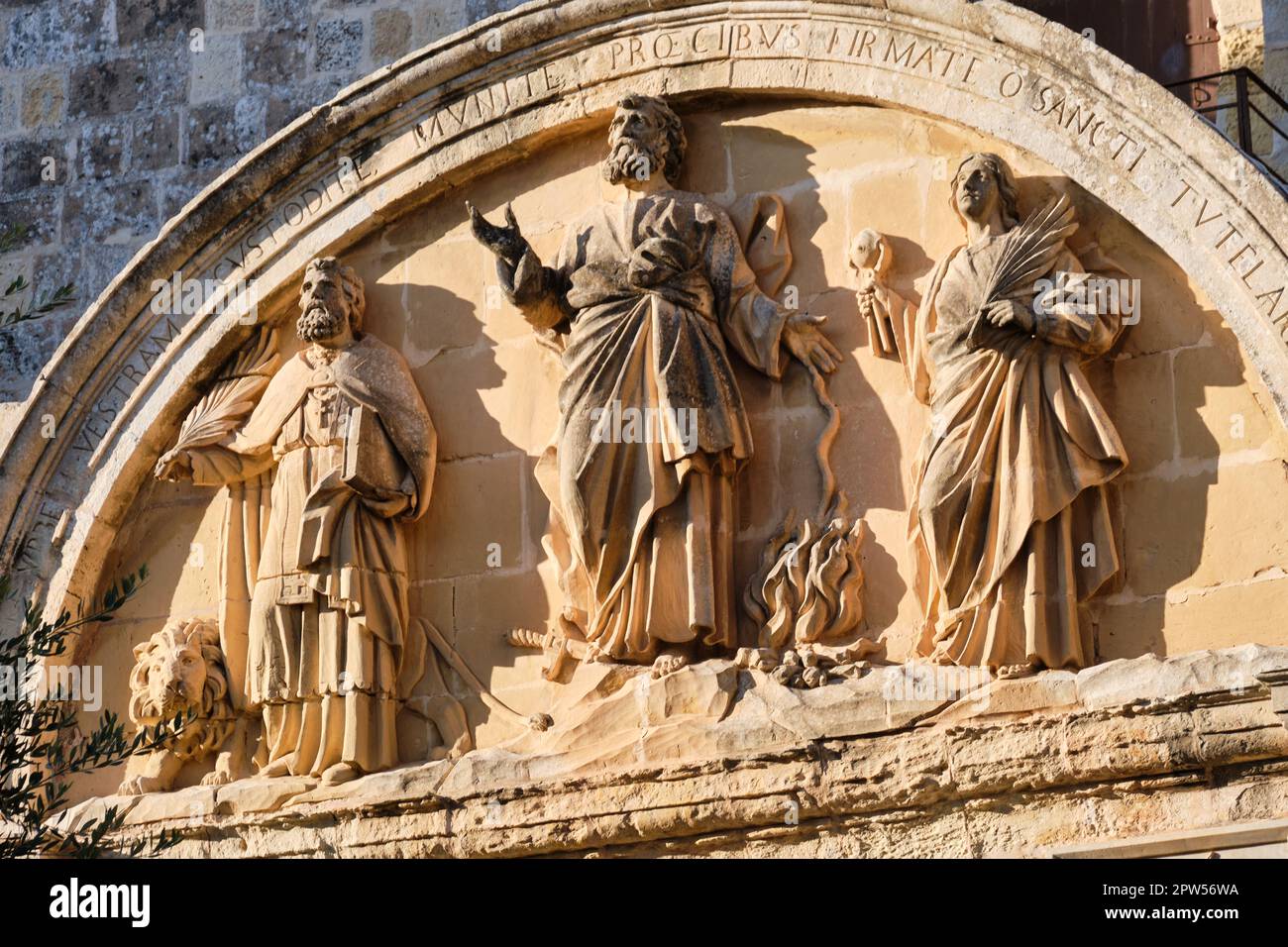 Relief à l'arrière de la porte principale présentant les saints patrons de Malte: St. Paul au centre avec St. Publius et Saint Agatha à ses côtés - Mdina Banque D'Images