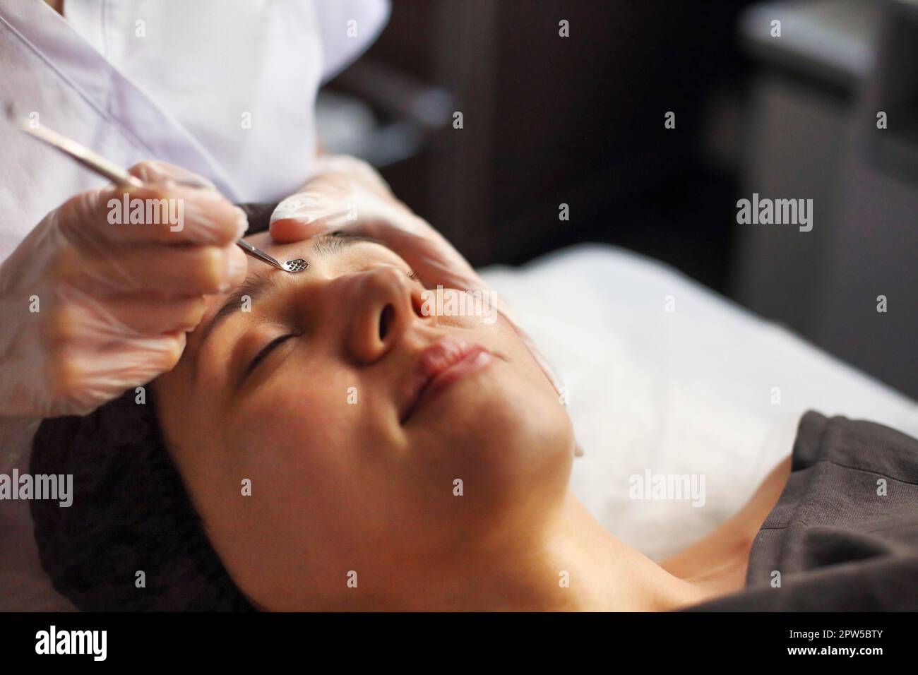 Nettoyage professionnel d'esthéticienne de l'acné de la femme pendant la procédure anti-vieillissement dans la clinique de beauté Banque D'Images