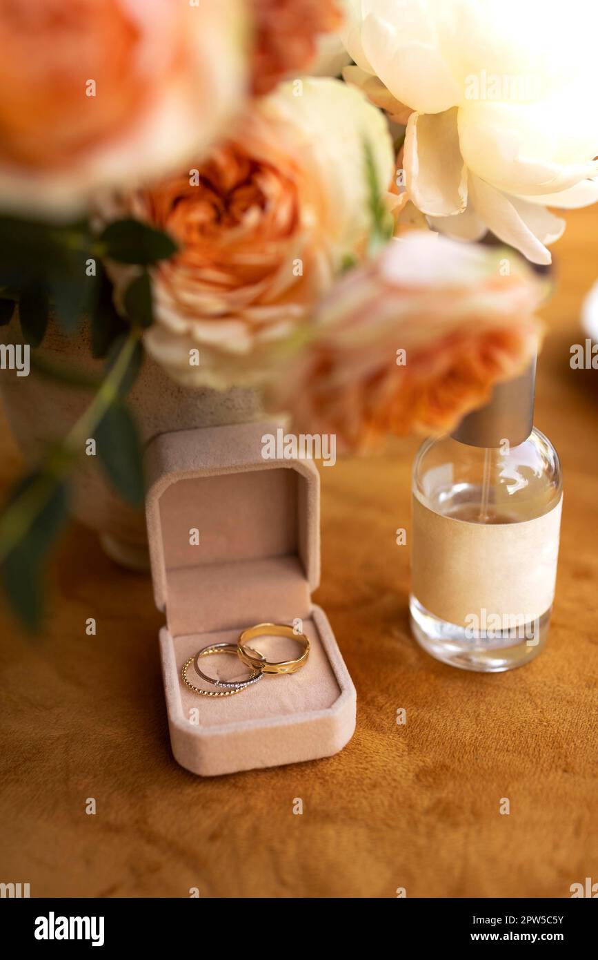 Anneaux de mariage dans la boîte, bouquet de fleurs près de la bouteille de parfum de mariée Anneaux de mariage dans la boîte, bouquet de fleurs près de la bouteille de parfum de mariée