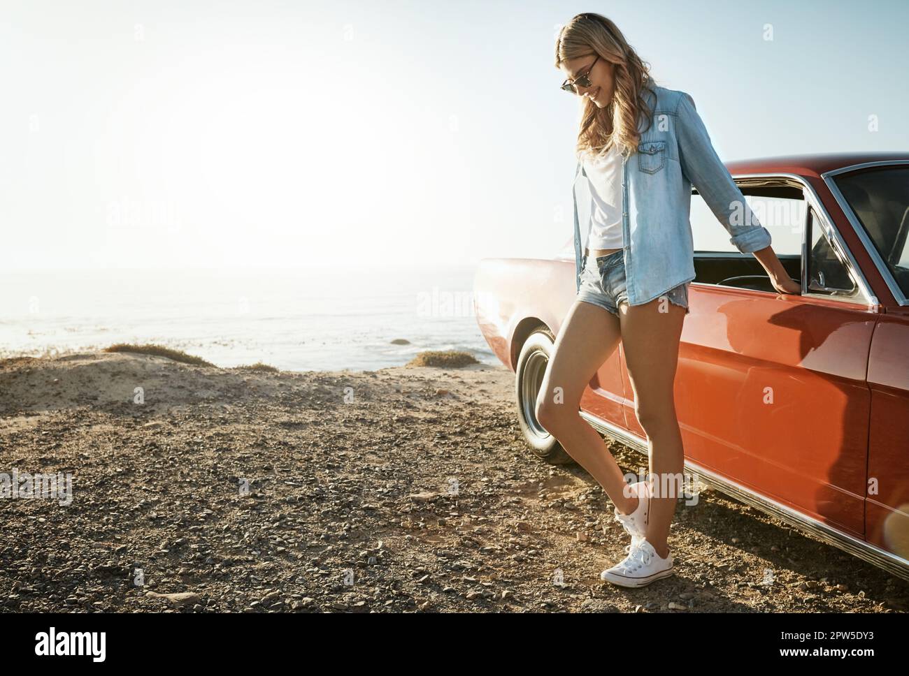 Mordu par le bogue de voyage. une belle jeune femme en voyage sur la route à la plage. Banque D'Images