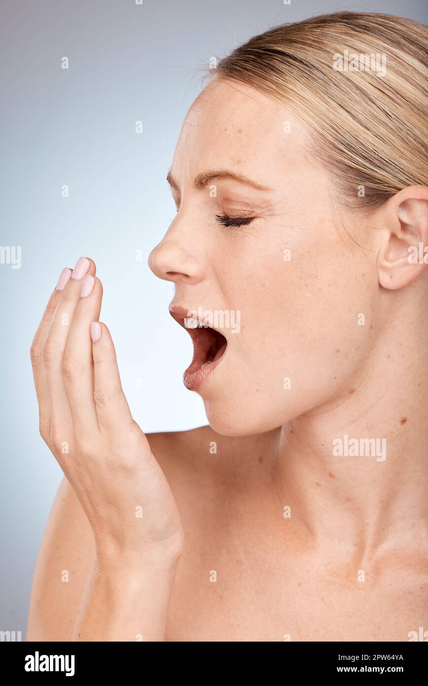 Souffle frais, odeur et femme odeur, soins de la bouche et hygiène dentaire sur un fond gris studio. Santé, santé bucco-dentaire et visage d'un modèle d'esprit Banque D'Images