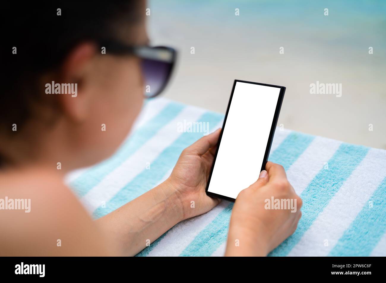 Téléphone mobile ou smartphone avec écran vert sur la plage Banque D'Images