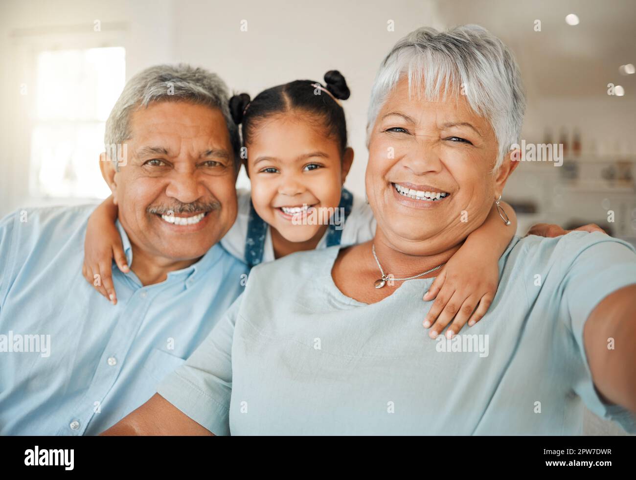 Pour nous, la famille signifie mettre vos bras les uns autour des autres. les grands-parents se sont solidaires de leur petite-fille sur un canapé à la maison Banque D'Images