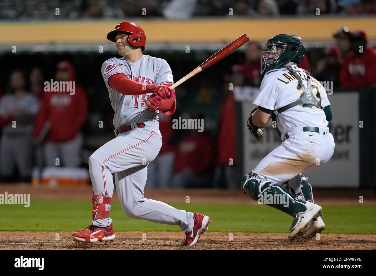 Cincinnati Reds' Nick Senzel, left, hits a two-run double in front of Oakland Athletics catcher Shea Langeliers during the seventh inning of a baseball game in Oakland, Calif., Friday, April 28, 2023. (AP Photo/Jeff Chiu) Banque D'Images