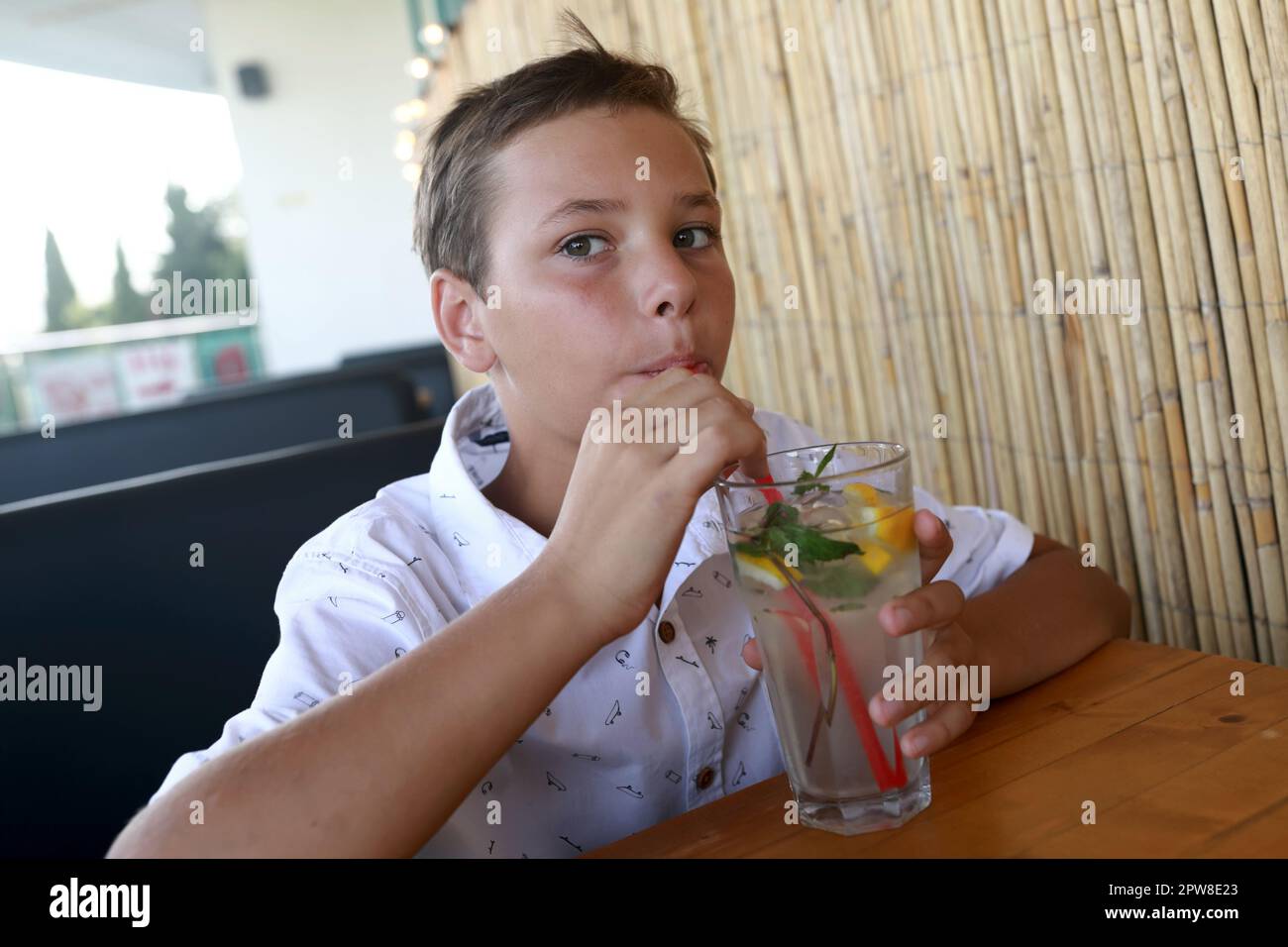 Portrait de l'enfant a la limonade dans le restaurant Banque D'Images