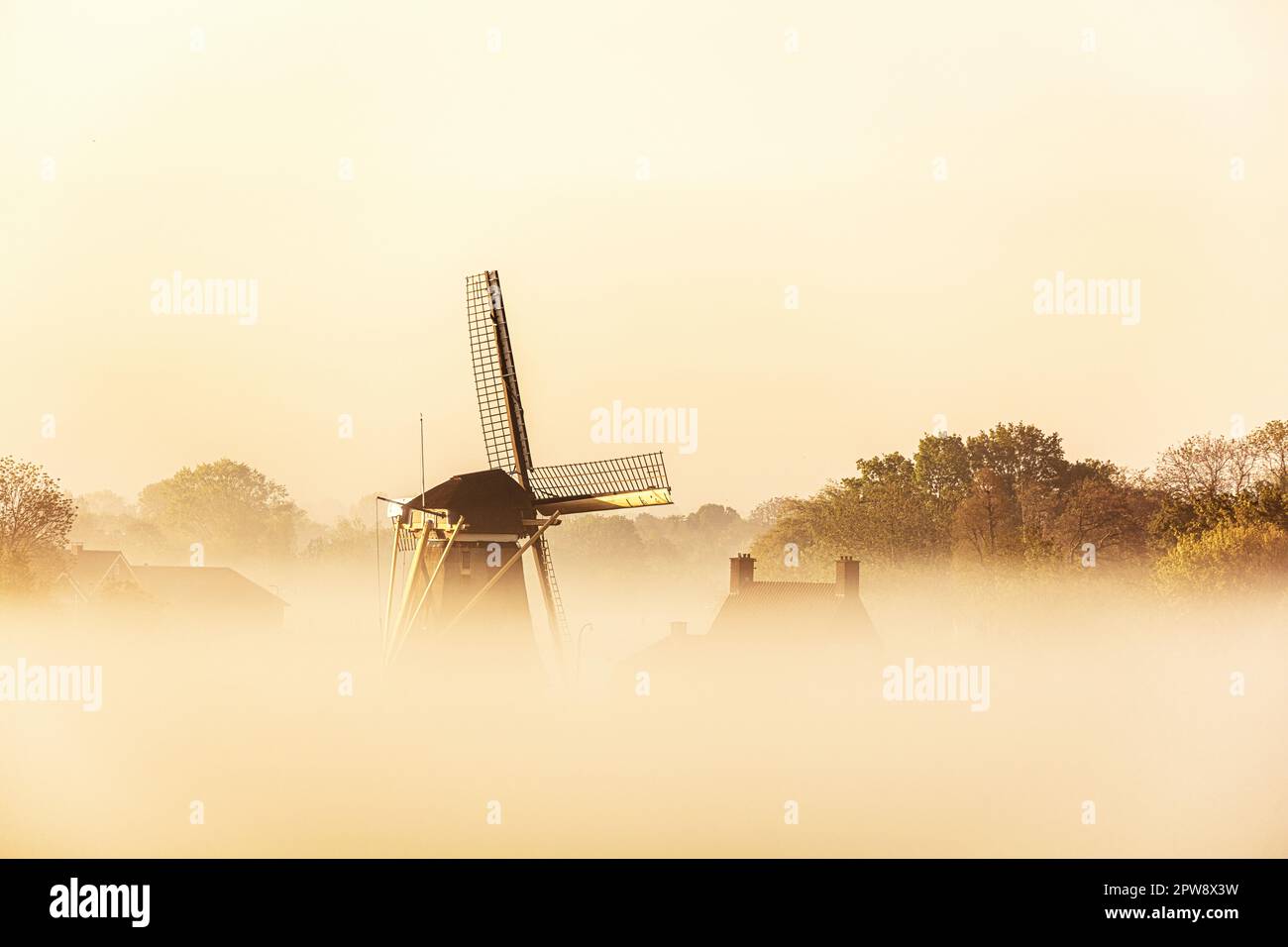 Pays-Bas, Nigtevecht. Moulin le long de la rivière Vecht, lever du soleil. Brume. Banque D'Images
