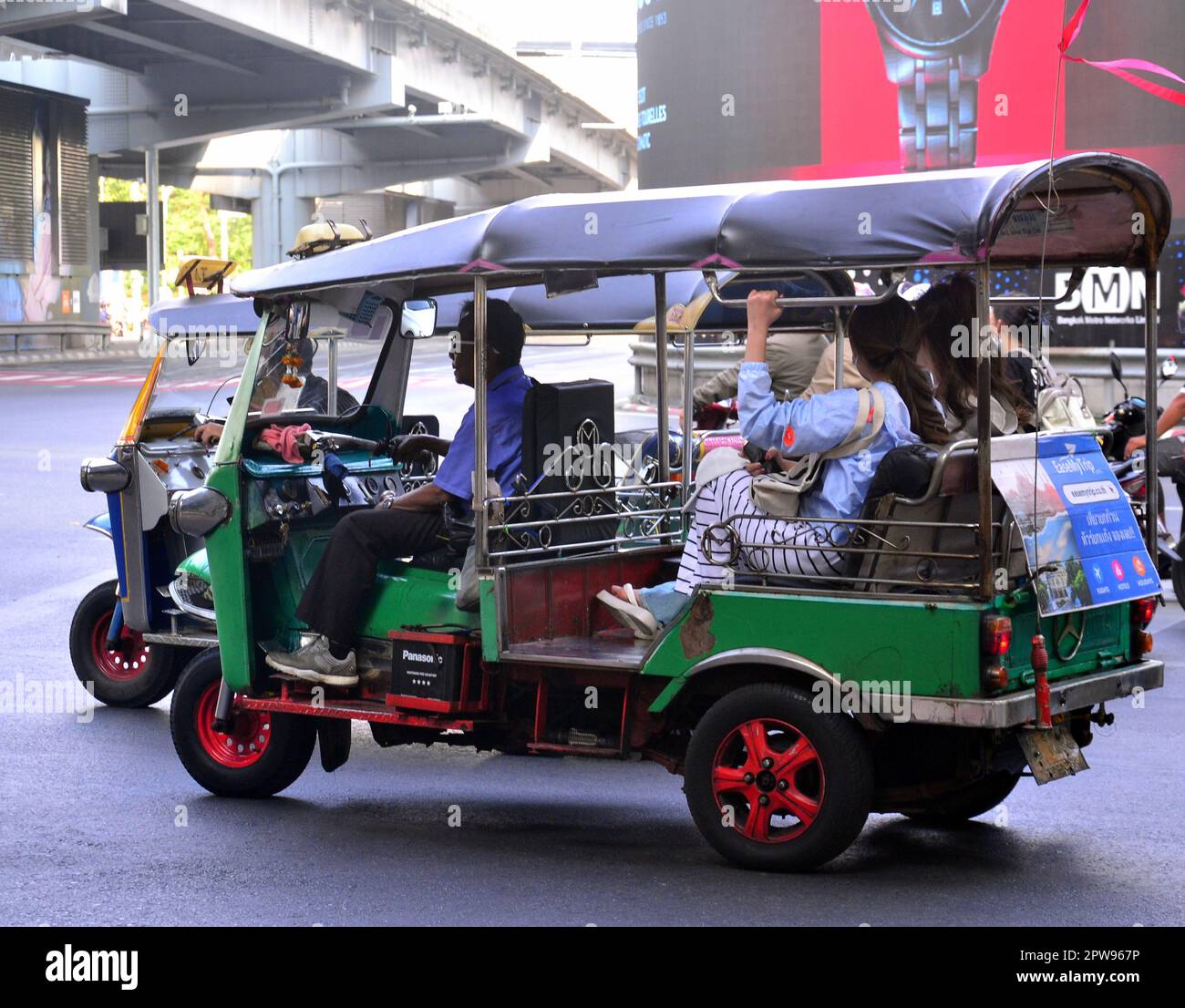 Travailleurs, Bangkok, Thaïlande, Asie. Les conducteurs de tuk tuk transportent des passagers dans le district de Silom. Sortie Silom Road avec Rama IV Road. Banque D'Images
