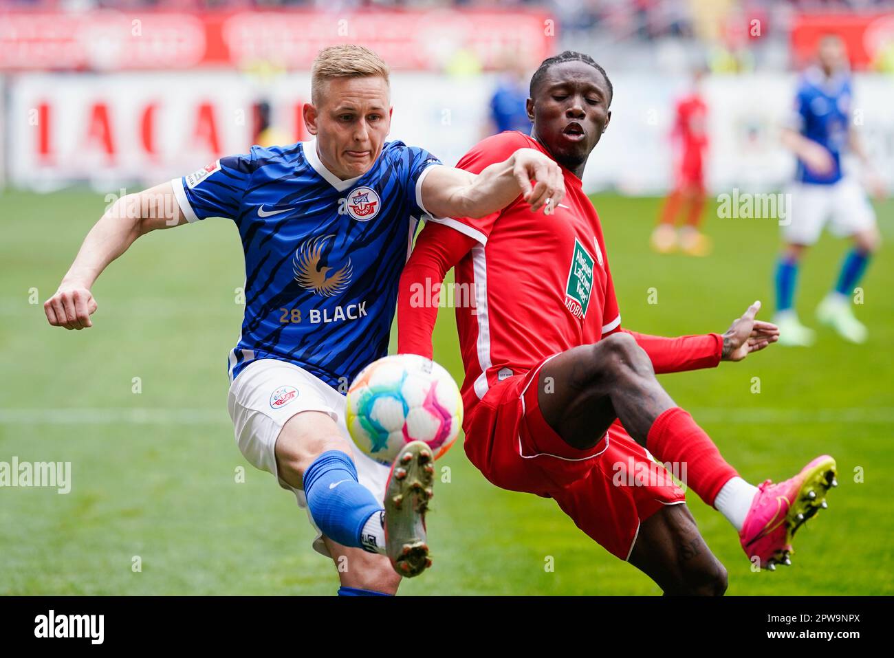 Kaiserslautern, Allemagne. 29th avril 2023. Football: 2nd Bundesliga, 1. FC Kaiserslautern - Hansa Rostock, Matchday 30, Fritz-Walter-Stadion. Kai Pröger de Rostock (l) et Aaron Opoku de Kaiserslautern se battent pour le ballon. Crédit : Uwe Anspach/dpa - REMARQUE IMPORTANTE : Conformément aux exigences de la DFL Deutsche Fußball Liga et de la DFB Deutscher Fußball-Bund, il est interdit d'utiliser ou d'avoir utilisé des photos prises dans le stade et/ou du match sous forme de séquences et/ou de séries de photos de type vidéo./dpa/Alay Live News Banque D'Images