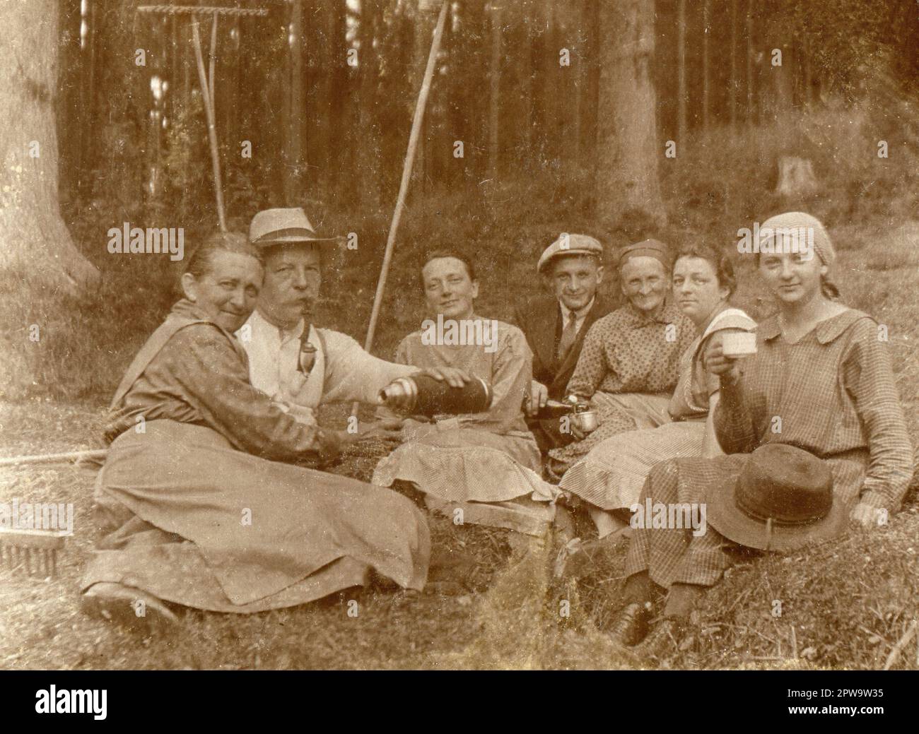 Silésie supérieure. 1930s. Un groupe de travailleurs agricoles prenant une  pause au bord d'une zone boisée. Le monsieur plus âgé fume un tuyau  traditionnel de chasseur en porcelaine et verse des boissons