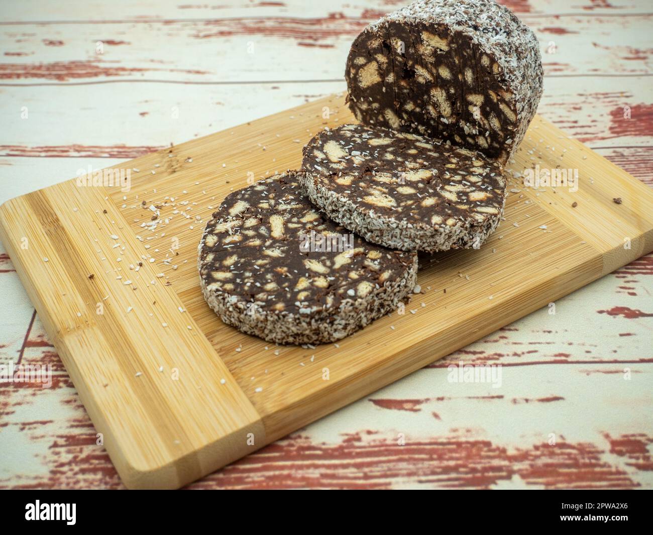 tranches de salami au chocolat avec biscuits sur une planche à découper Banque D'Images