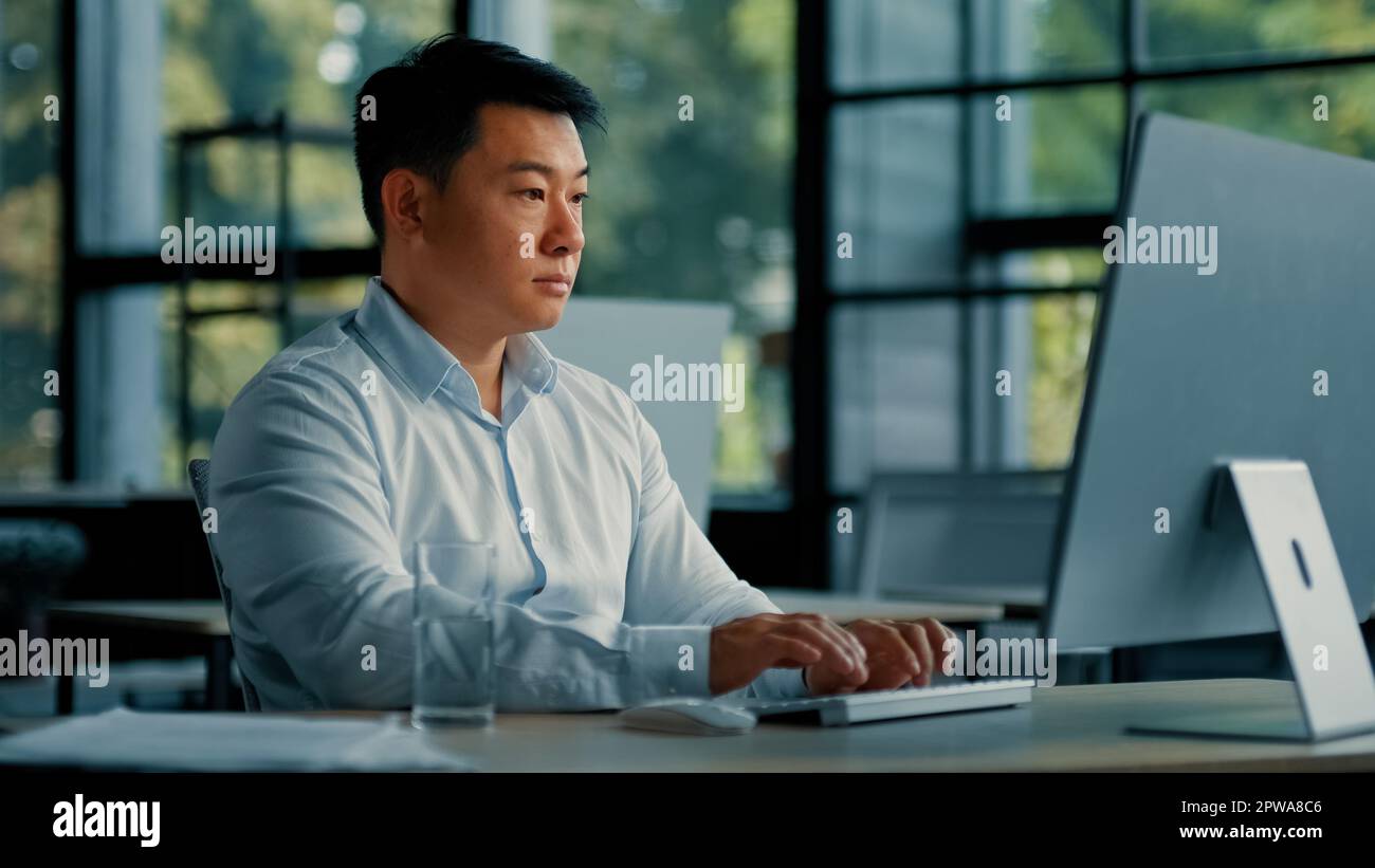 Professionnel homme d'affaires asiatique coréen homme d'affaires réussi programmeur spécialiste s'assoir au bureau de travail avec le programme de logiciel d'ordinateur Banque D'Images