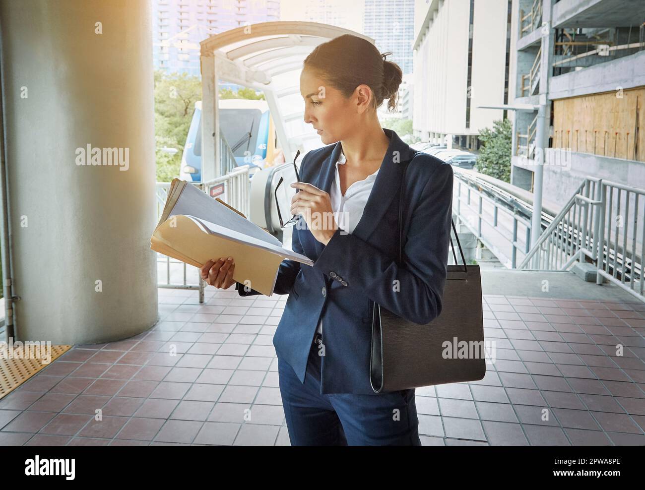 Se brosser les dents sur le chemin d'une réunion. une jeune femme d'affaires lisant des documents sur son chemin vers le bureau. Banque D'Images
