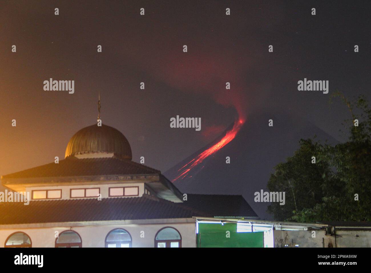 Sleman, Yogyakarta, Indonésie. 29th avril 2023. Le mont Merapi déversant de la lave incandescente chaude contre une mosquée en premier plan est vu à Boyong, Sleman, Yogyakarta, Indonésie, samedi, 29 avril 2023. Selon les informations du Centre de recherche et de développement en technologie des catastrophes géologiques de Yogyakarta (BPPTKG), des nuages chauds avalanches du Mont Merapi sur 29 avril 2023 durée de 192 secondes avec une distance de glissement de 2500 mètres au sud-ouest, à savoir à Kali Bebeng. (Credit image: © Slamet Riyadi/ZUMA Press Wire) USAGE ÉDITORIAL SEULEMENT! Non destiné À un usage commercial ! Banque D'Images