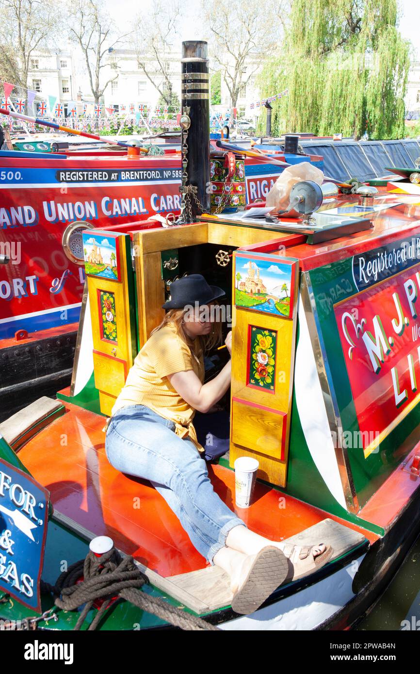 Londres, Royaume-Uni, 29 avril 2023 : lors de la cavalcade annuelle 40th de Canalway dans la petite Venise de Londres, Nicola retouchez la peinture du bateau EMU. Des événements familiaux et diverses compétitions entre propriétaires de bateaux ont lieu tout au long du week-end des vacances en banque. Anna Watson/Alay Live News. Banque D'Images