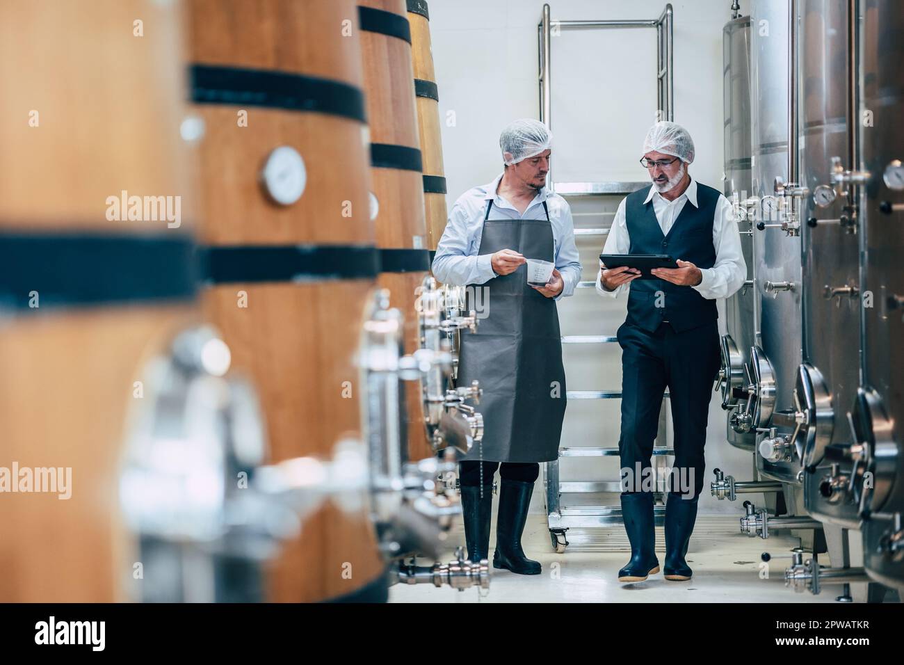 Viticulteur travaillant dans une grande usine moderne de vins alcool industrie de boisson qualité et contrôle de fermentation Banque D'Images